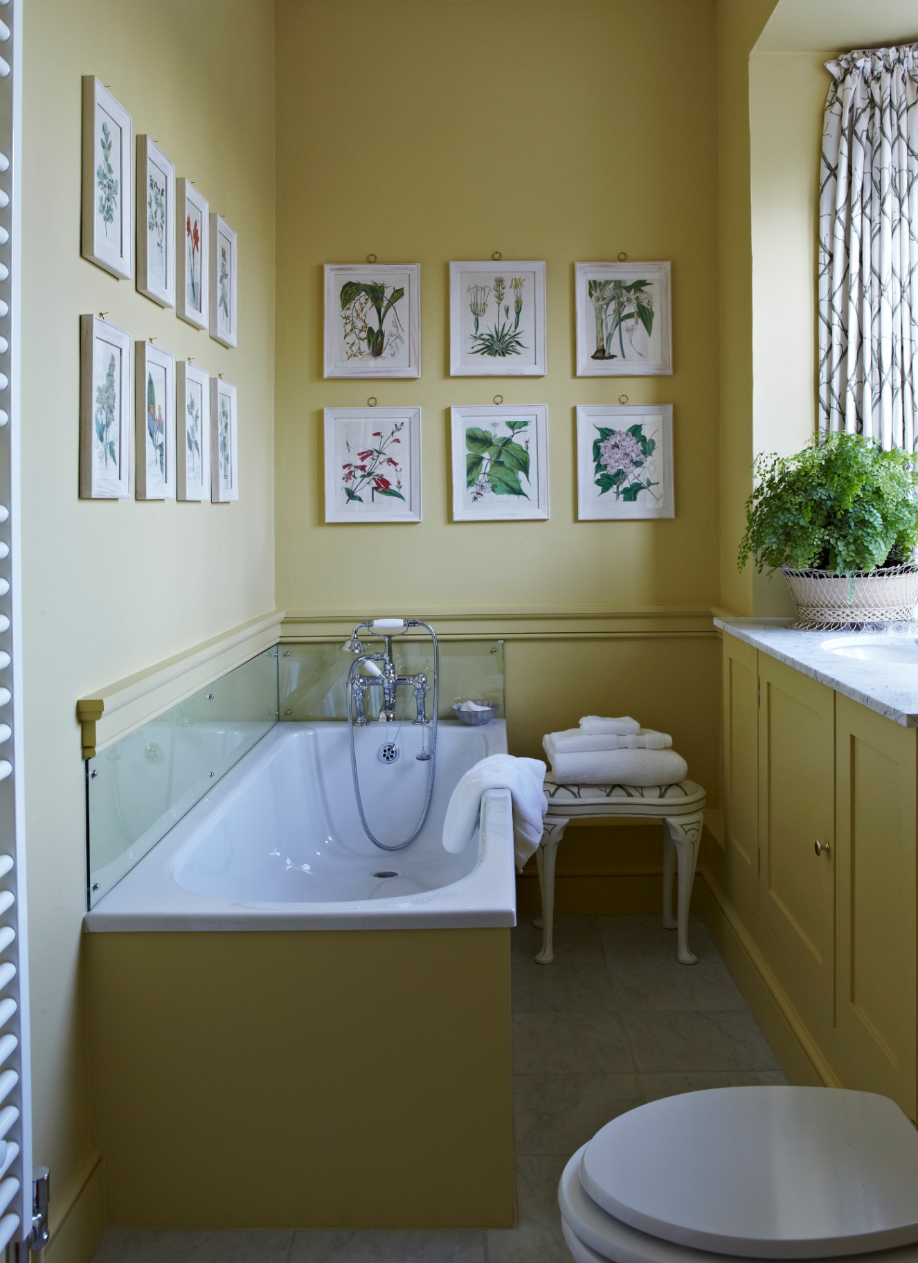 a bathroom with colour drenched walls, bath and cupboard in pale yellow