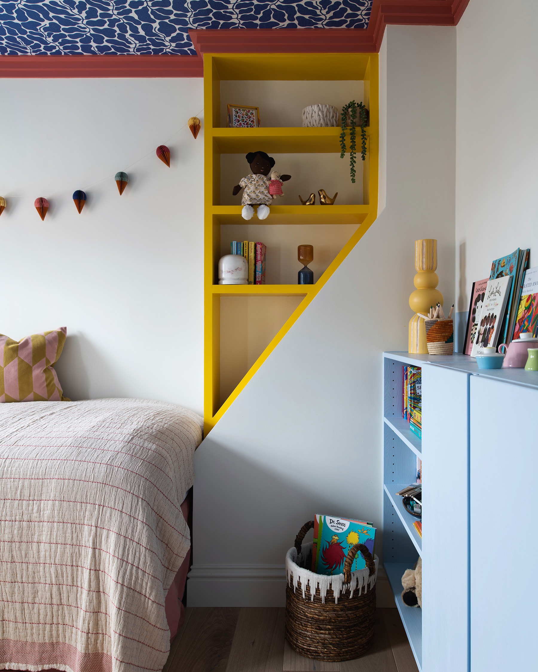 a childrens bedroom corner with a yellow painted alcove shelf