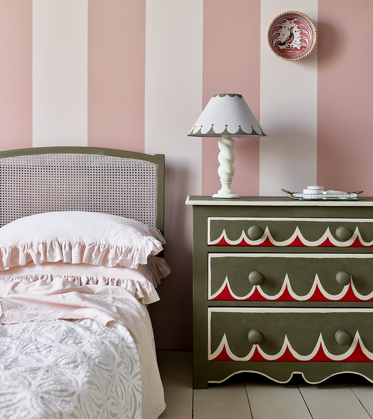 bedroom with pink and white stripe walls and a green painted chest of drawers