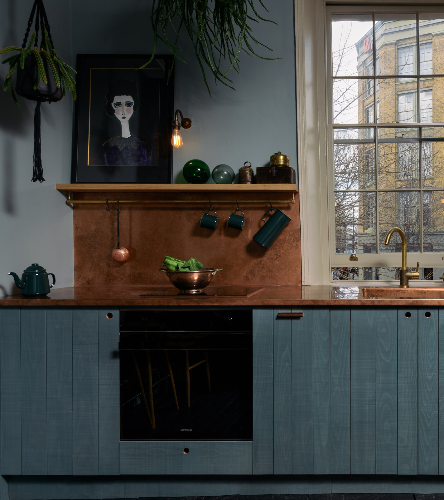 a dark kitchen with art work on shelf