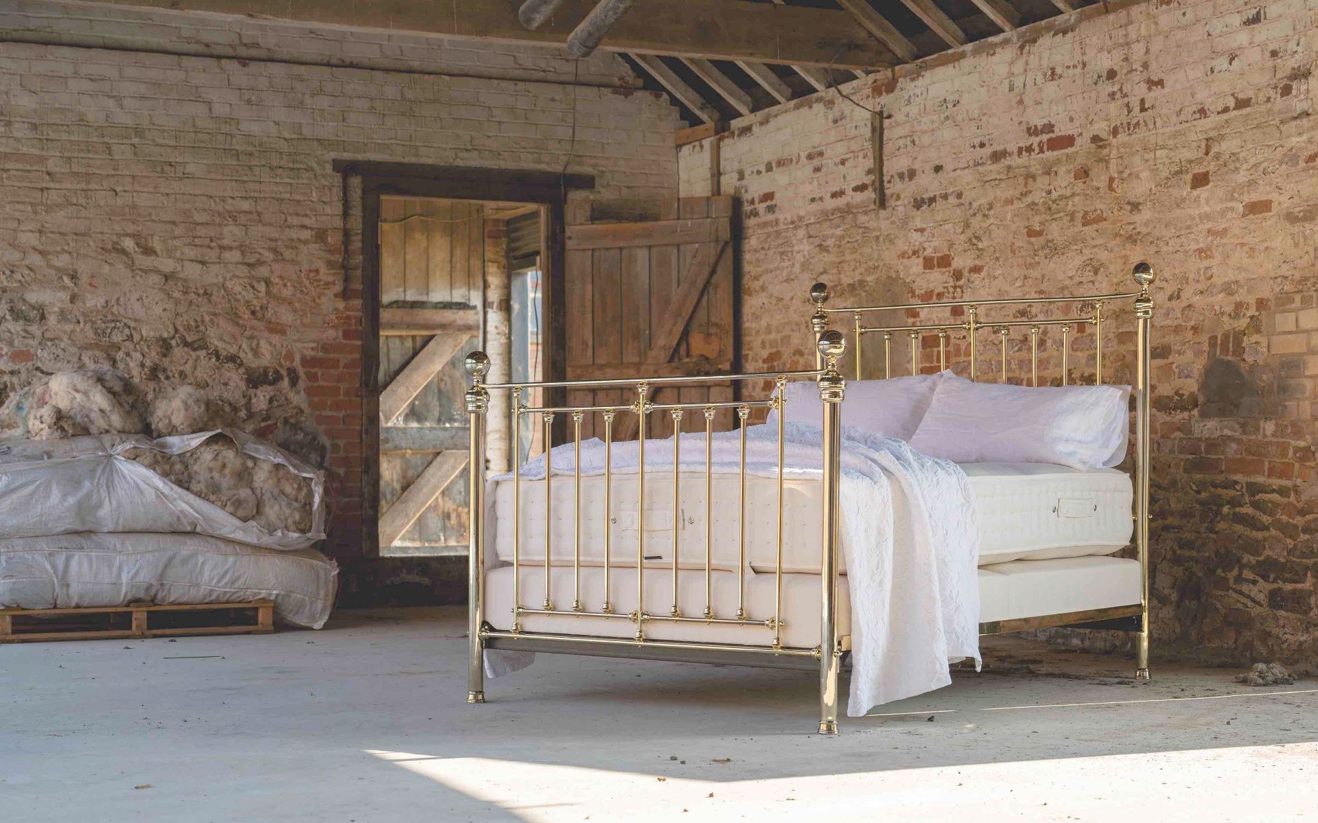 Traditional brass bed frame with British wool in a rustic farm building