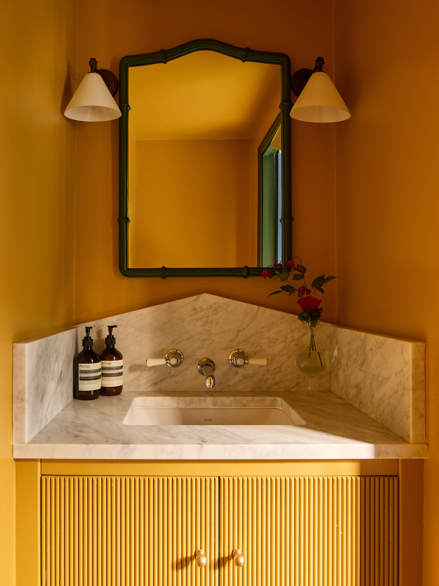 a bright yellow small bathroom pictured with a statement vanity in marble in a small space