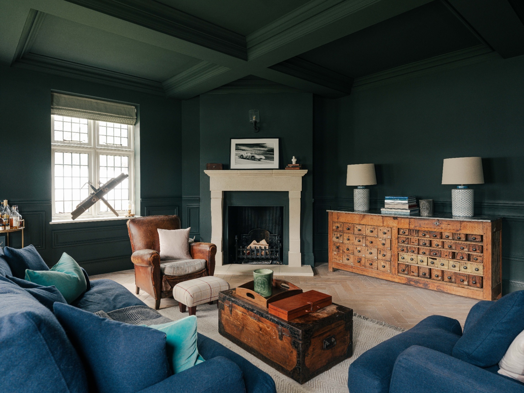 a beautiful living room pictured with an antique leather armchair from Sunbury Antiques Market features at the centre of the drawing room and dark accents