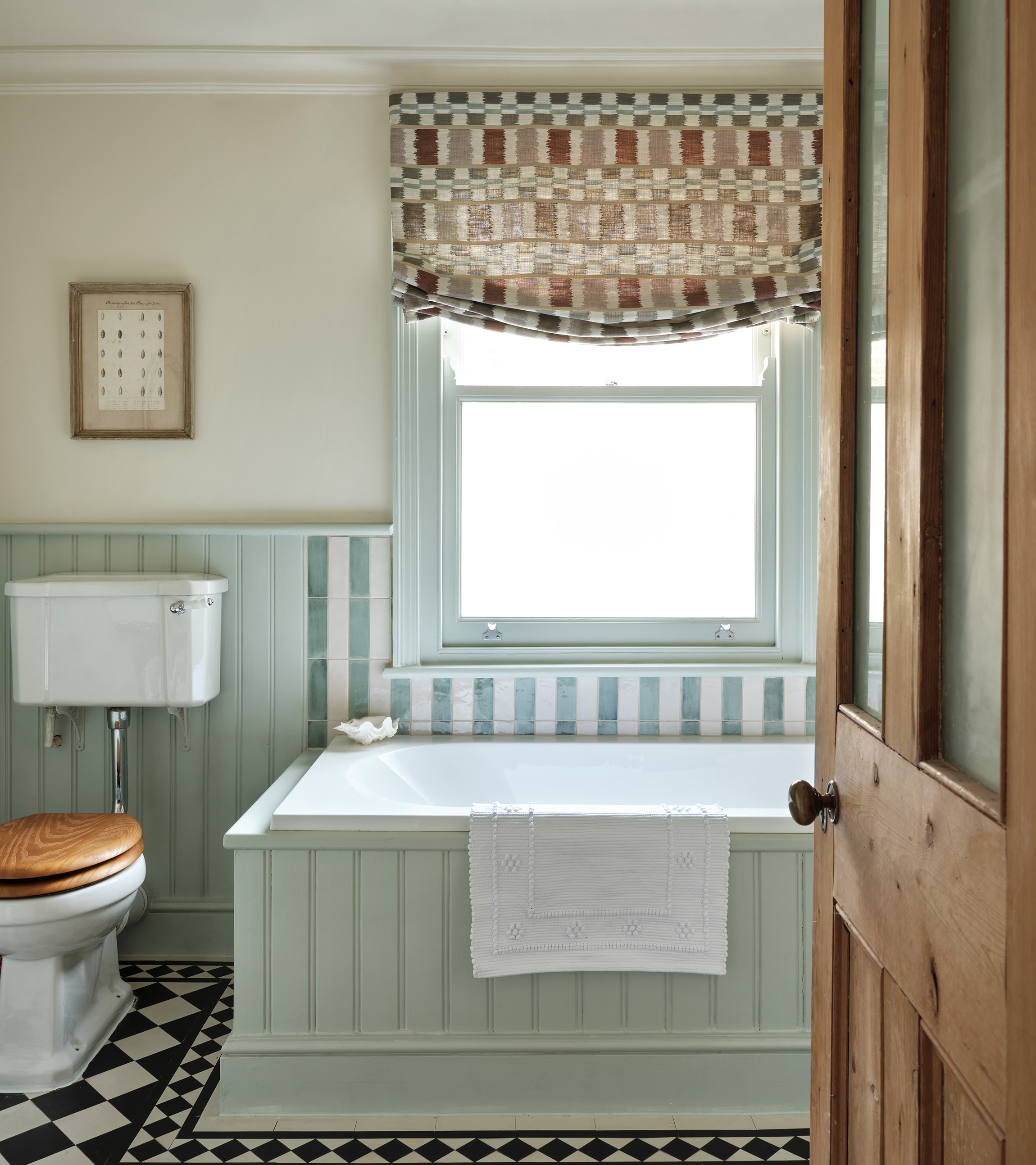 pandora taylor sage green bathroom with an oak door and toilet seat, a brown batterns blind and black and white checkered flooring