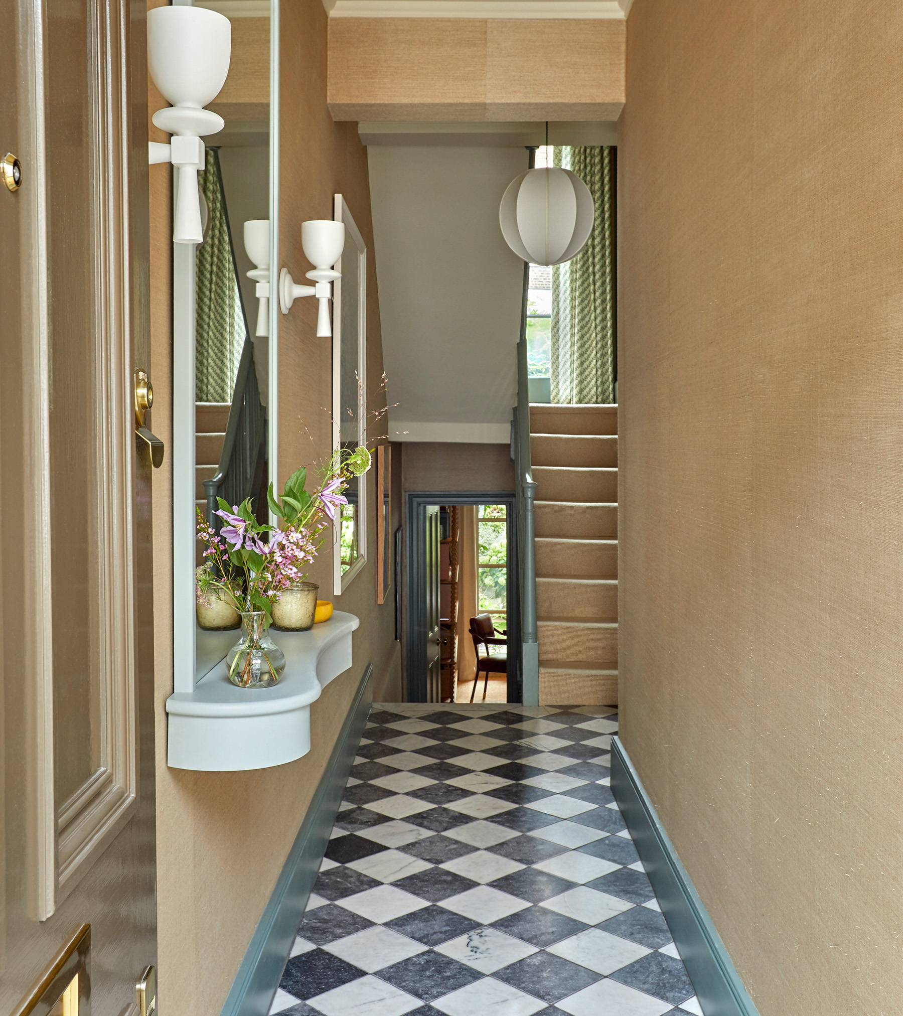 a narrow hallway with yellow walls and checkerboard flooring