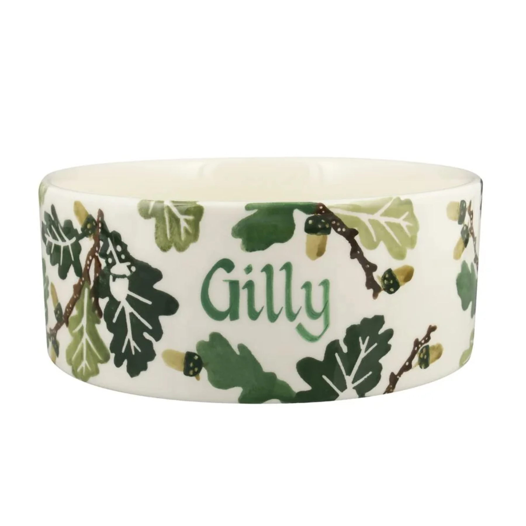 a white ceramic dog bowl with painted green oak leaves and the name gilly