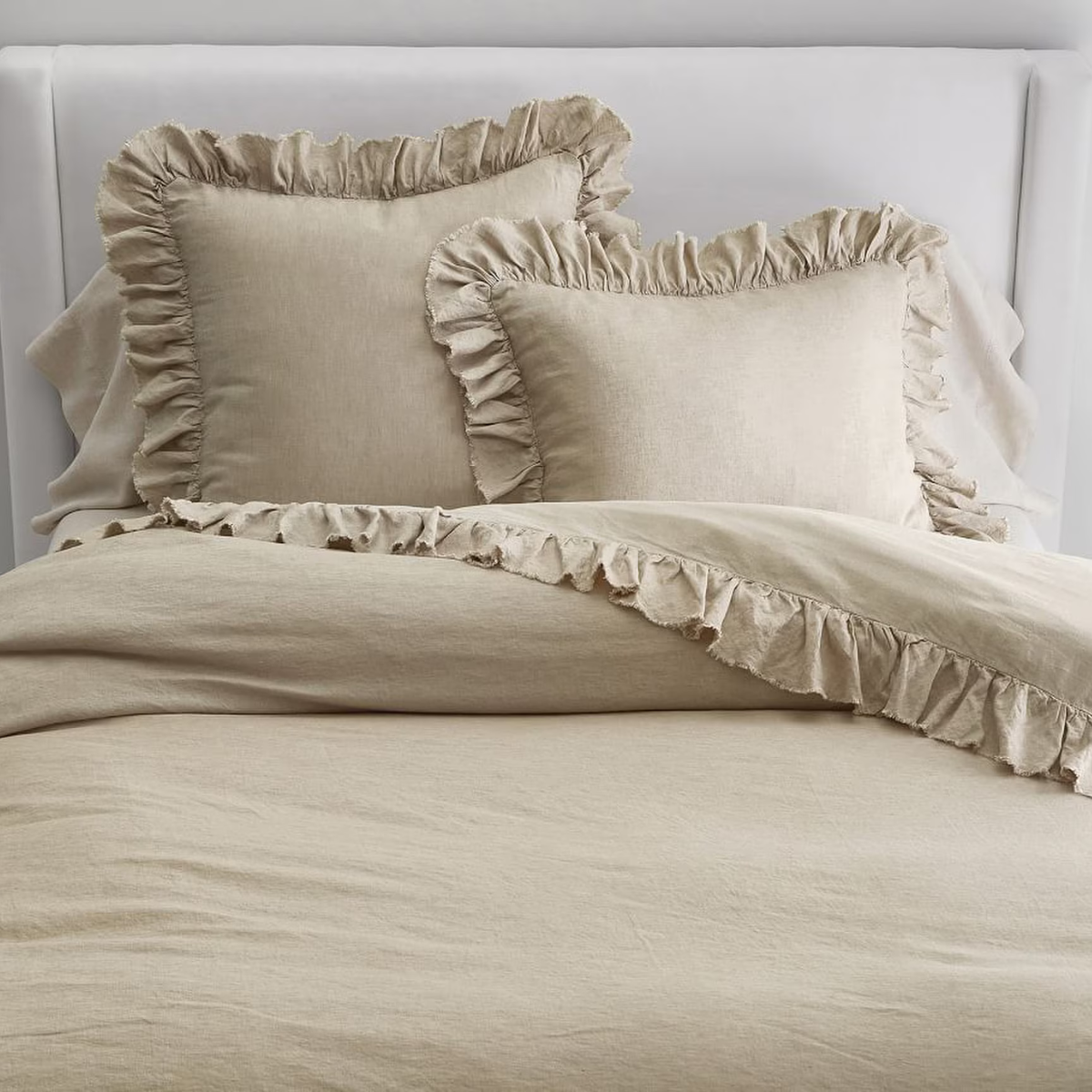 a beige ruffle trim duvet cover and pillows