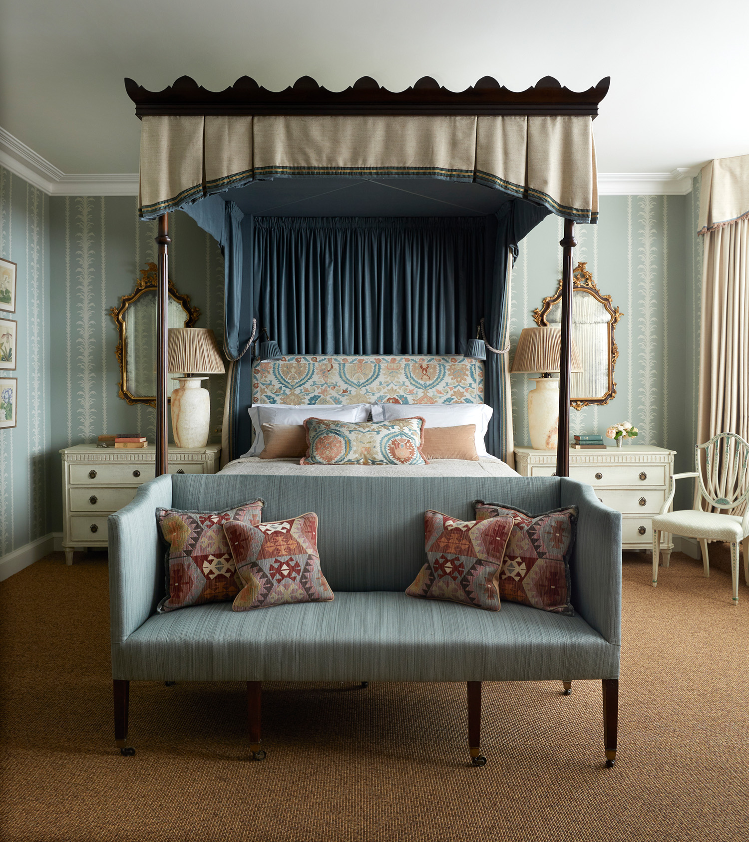 a four poster bed with canopy and bench at foot of bed