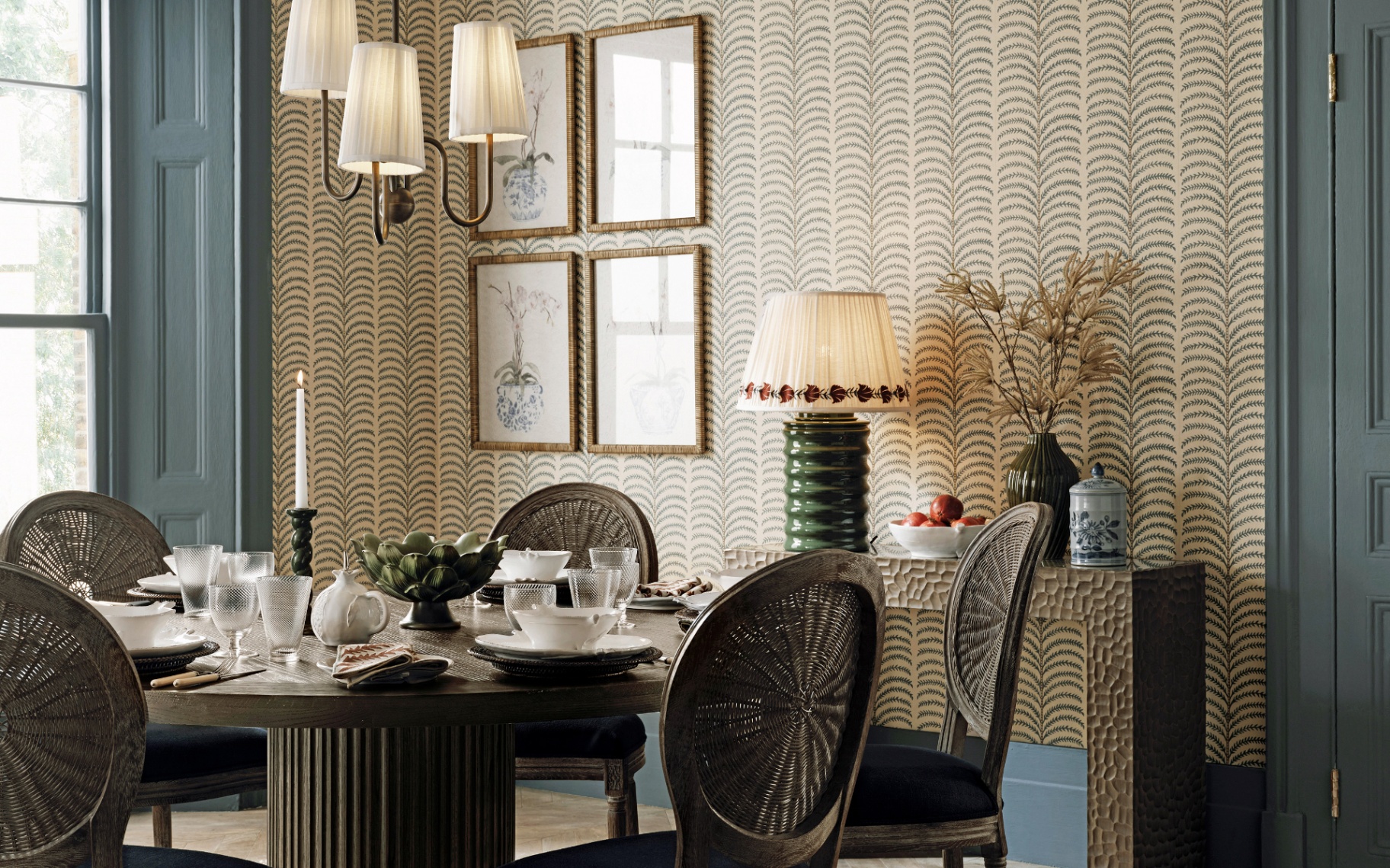 a dining room with a cream and green botanical wallpaper