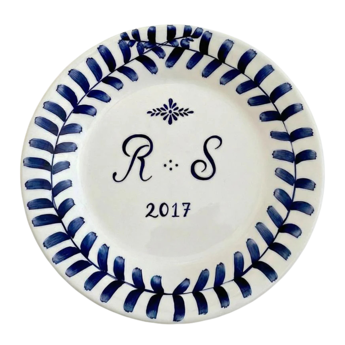 a white personalised monogram plate with blue lettering and pattern
