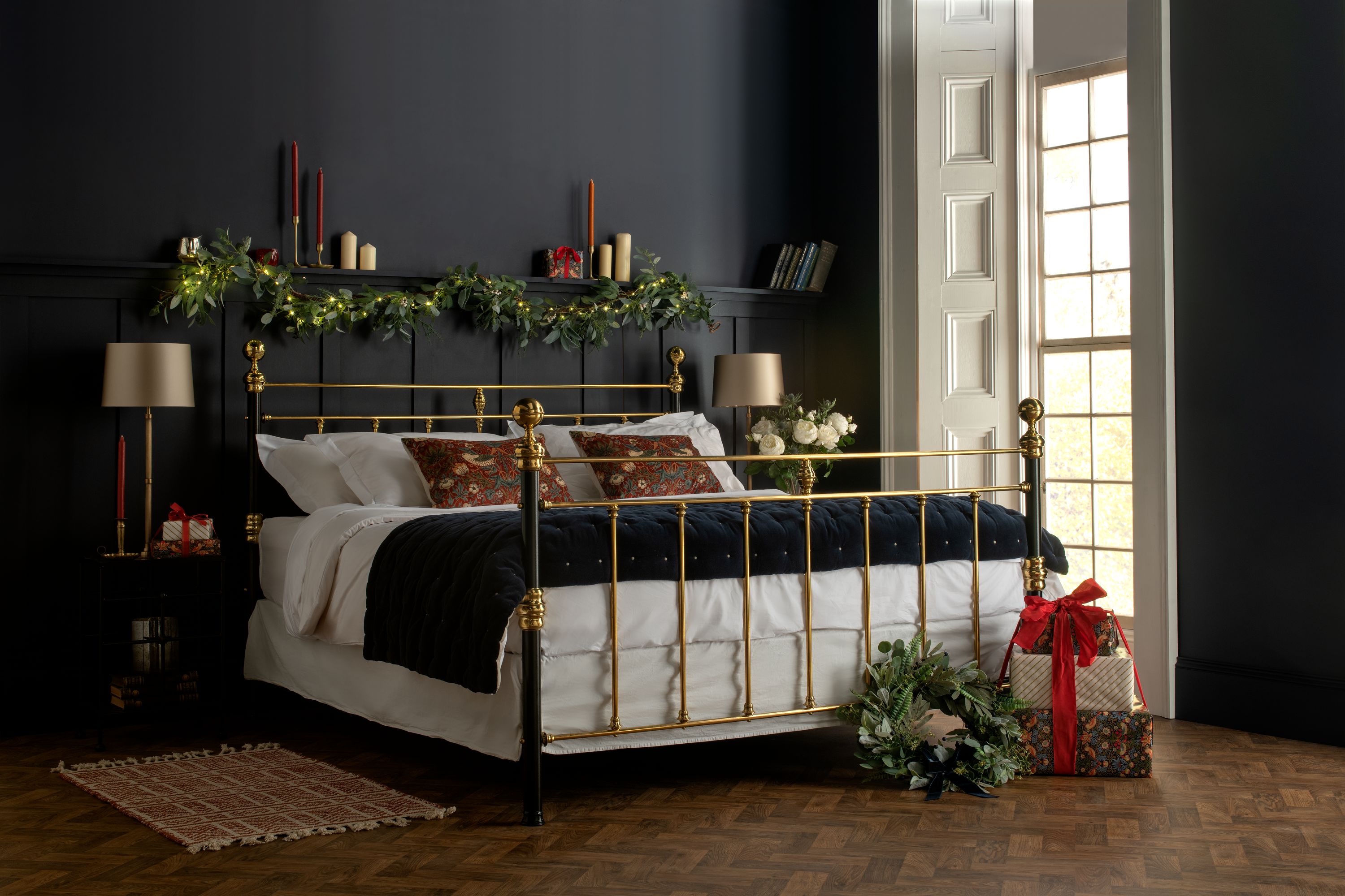 Traditional brass bed dressed for Christmas in a dark bedroom