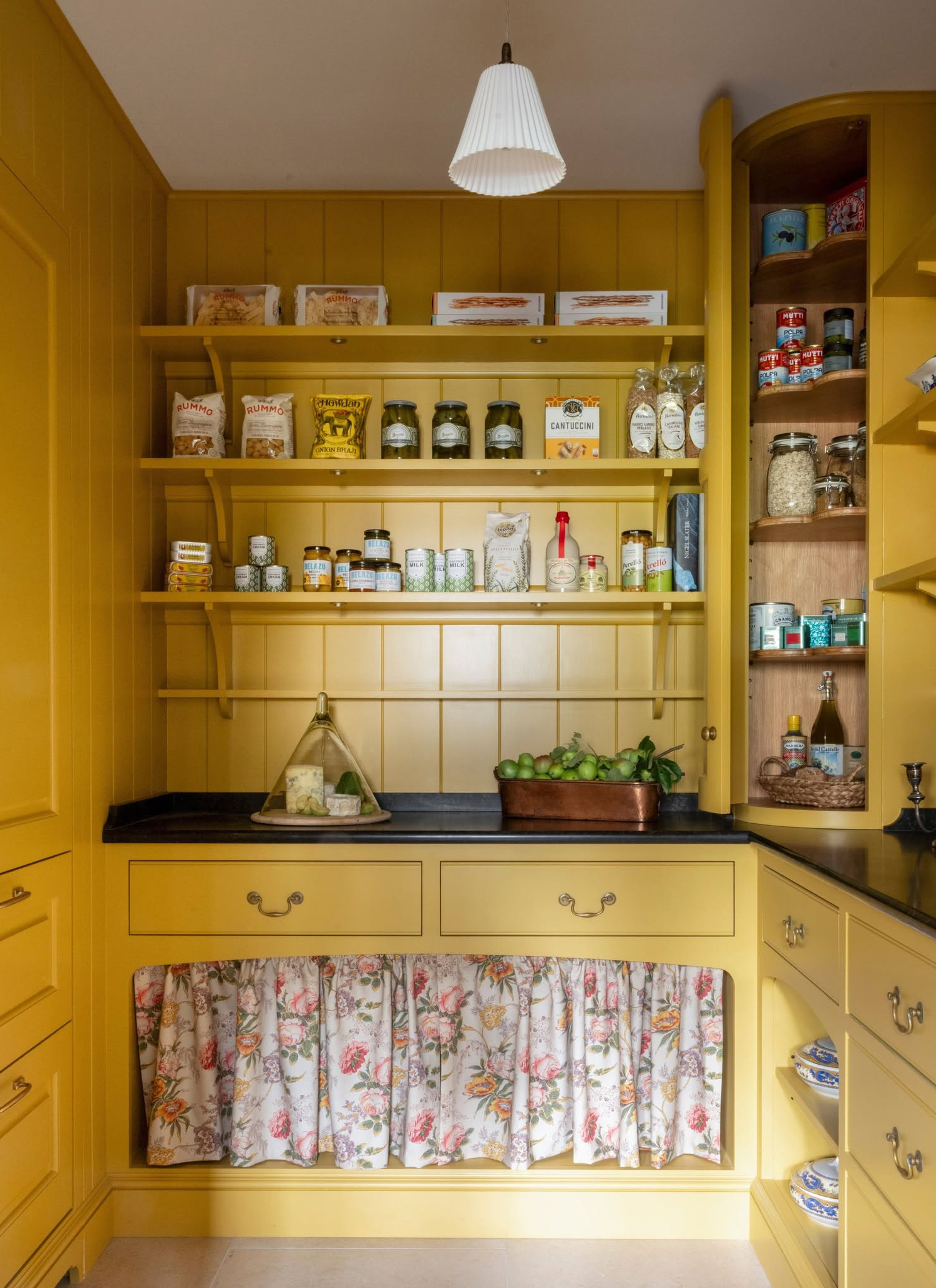 a kitchen with bright yellow colour drenched cabinets and open shelving
