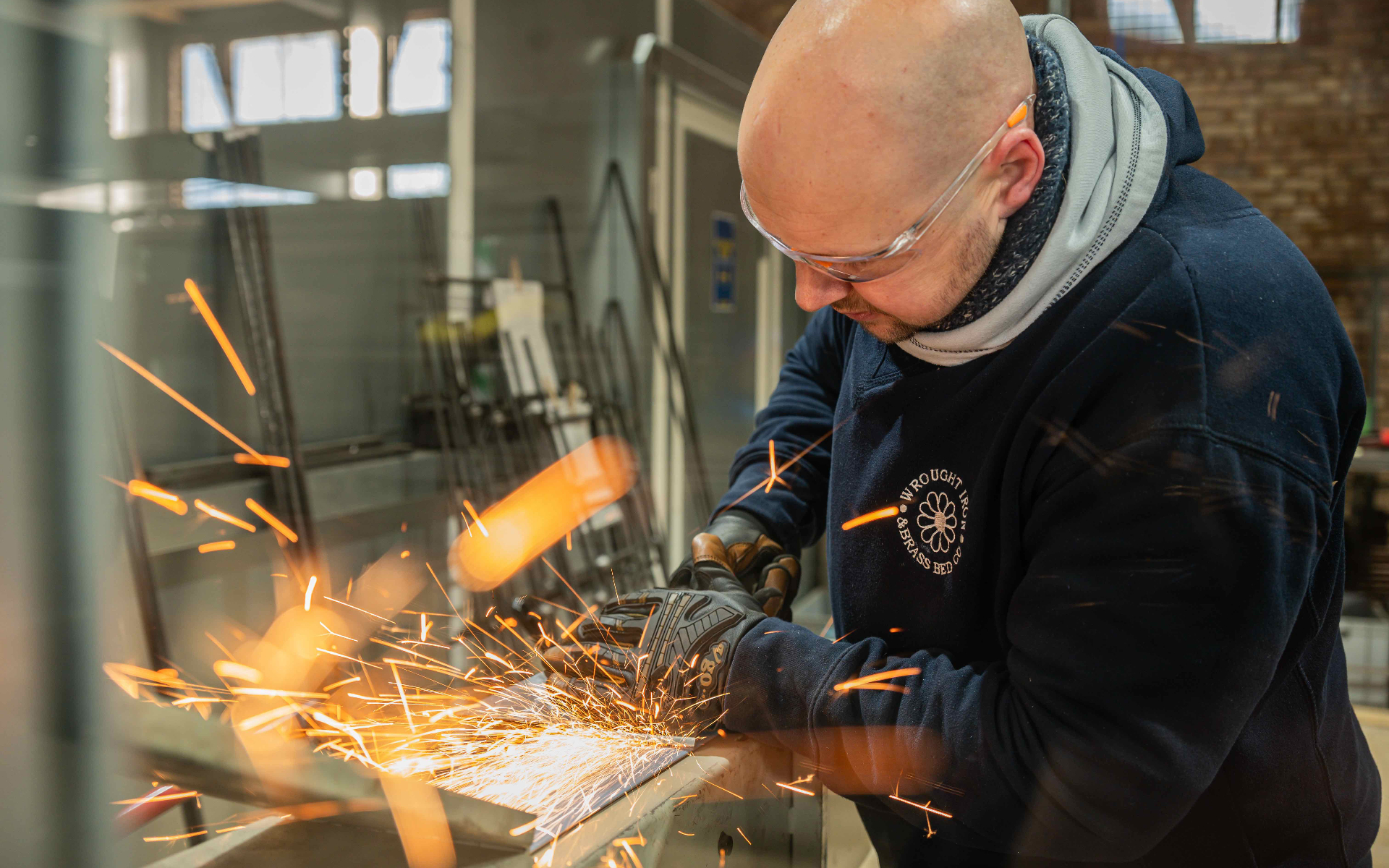 a man with a welder making an iron bed