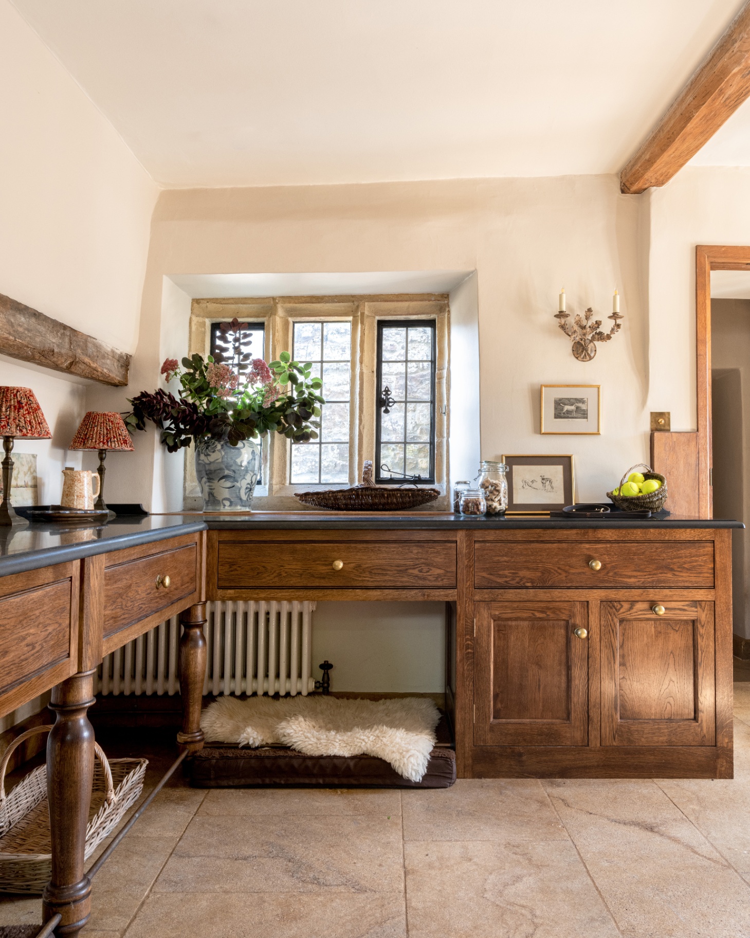 a country boot room with a large wooden side board with a dedicataed dog bed underneath next to a radiator