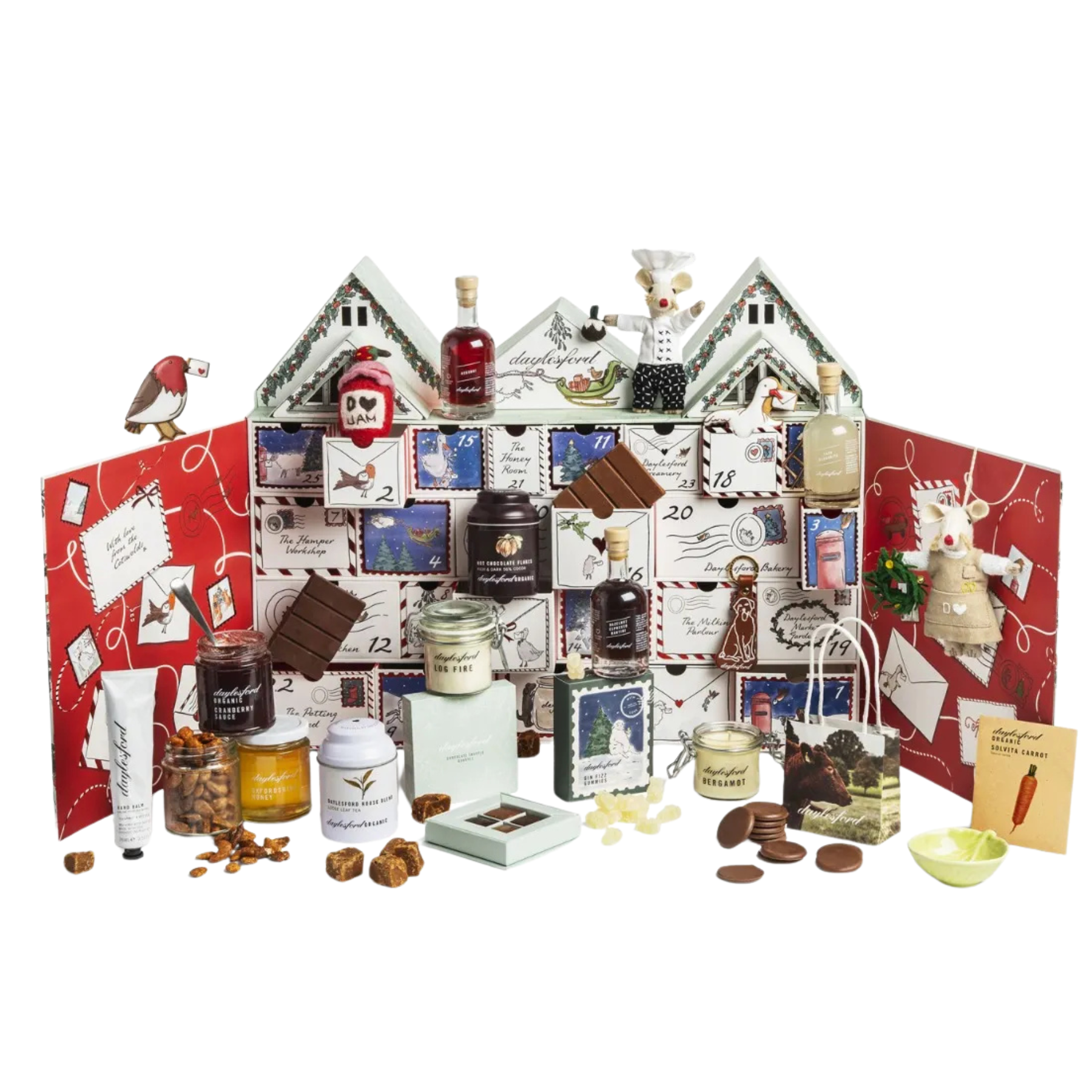 Daylesford Organic advent calendar shaped like farmhouses, surrounded by organic jams, teas, treats, candles, and decorative mice felt ornaments