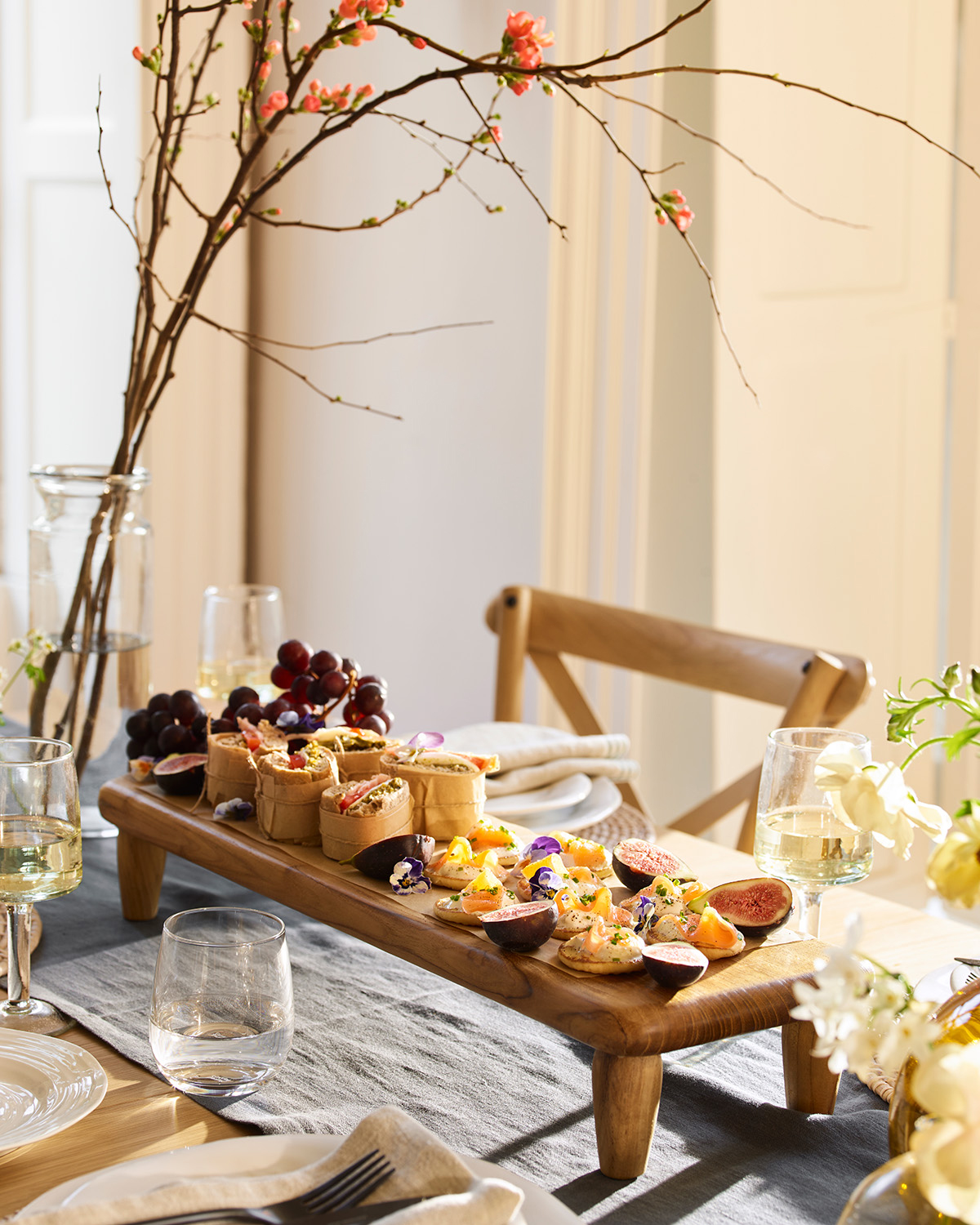 a spring table with a raised wooden serving board filled with food