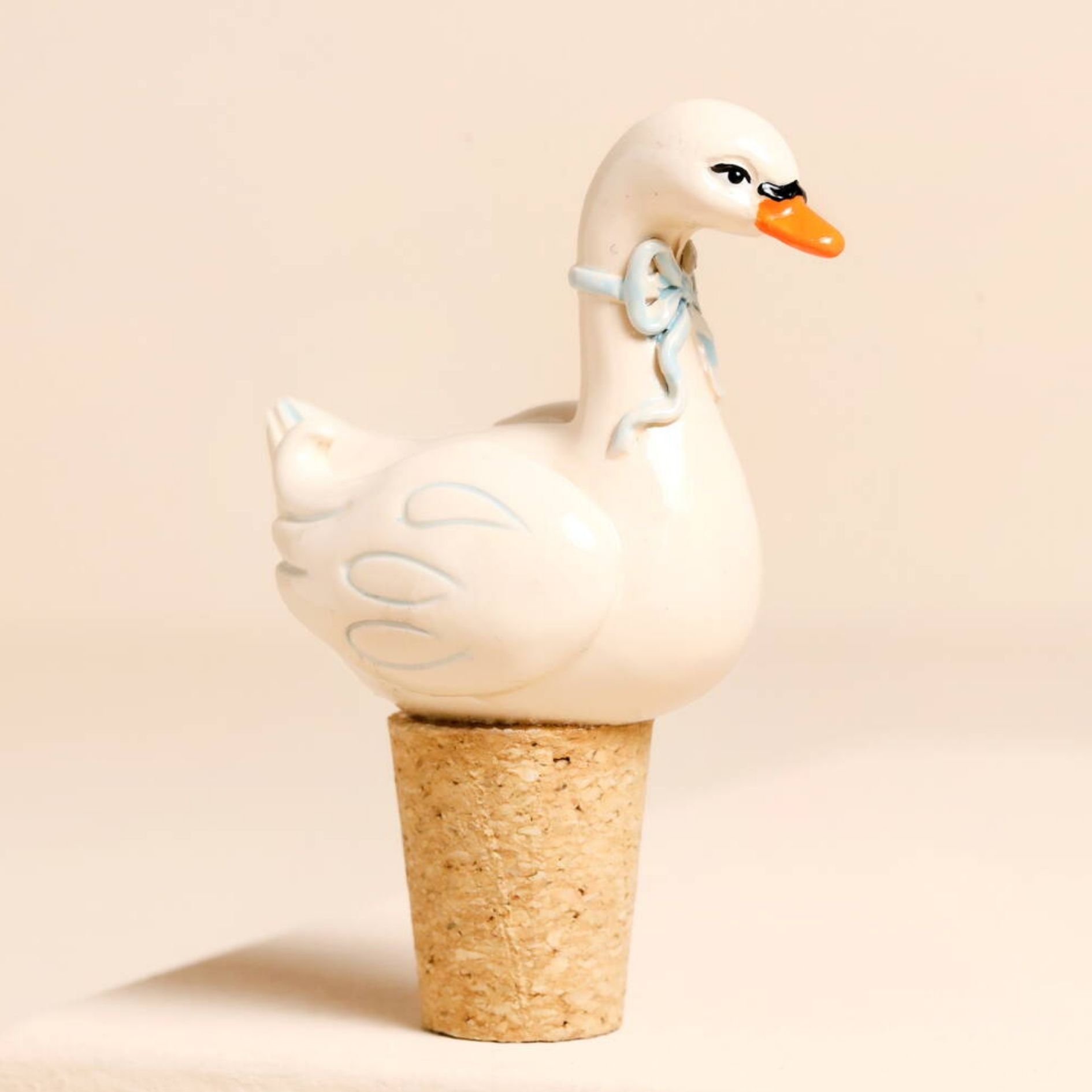 Swan Cork Bottle Stopper in resin pictured on a beige background