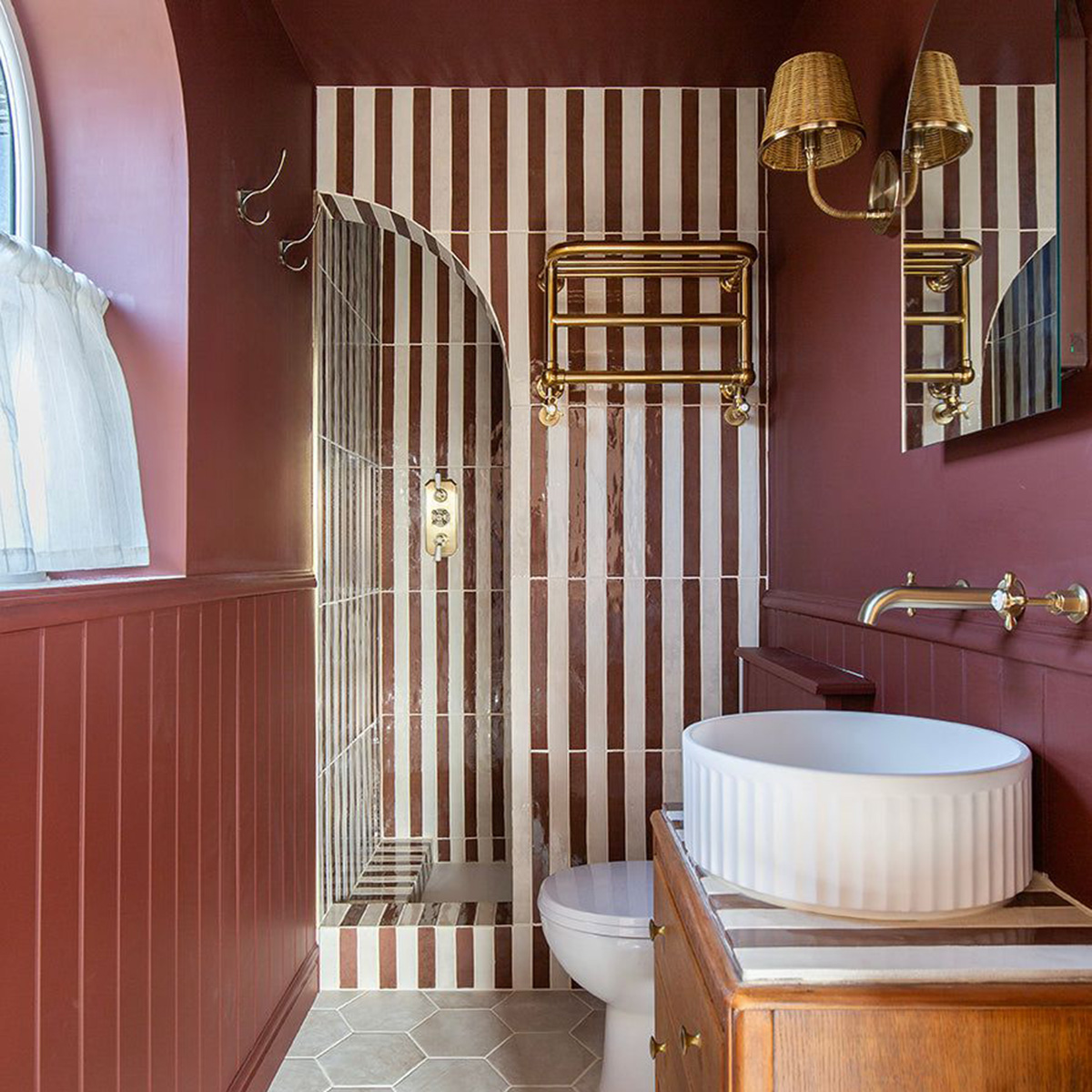 deep red bathroom with vertical stripe tiled shower