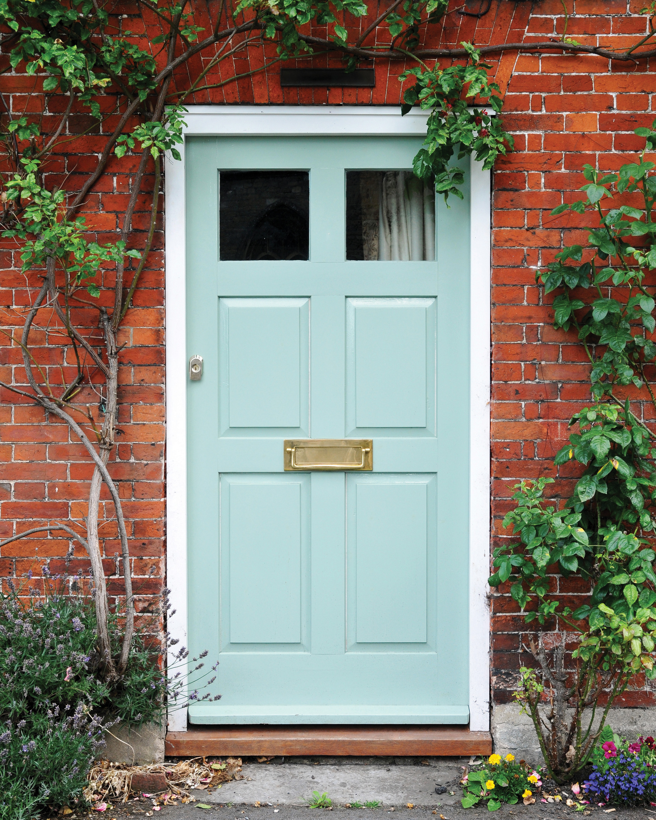 a red brick house with a pale blue front door