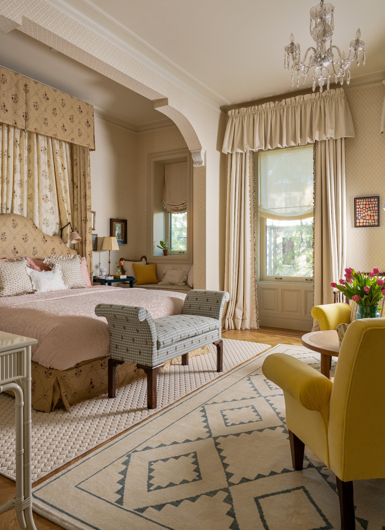 An elegant bedroom alcove featuring a traditional crystal chandelier suspended from the ceiling near a cozy bed canopy