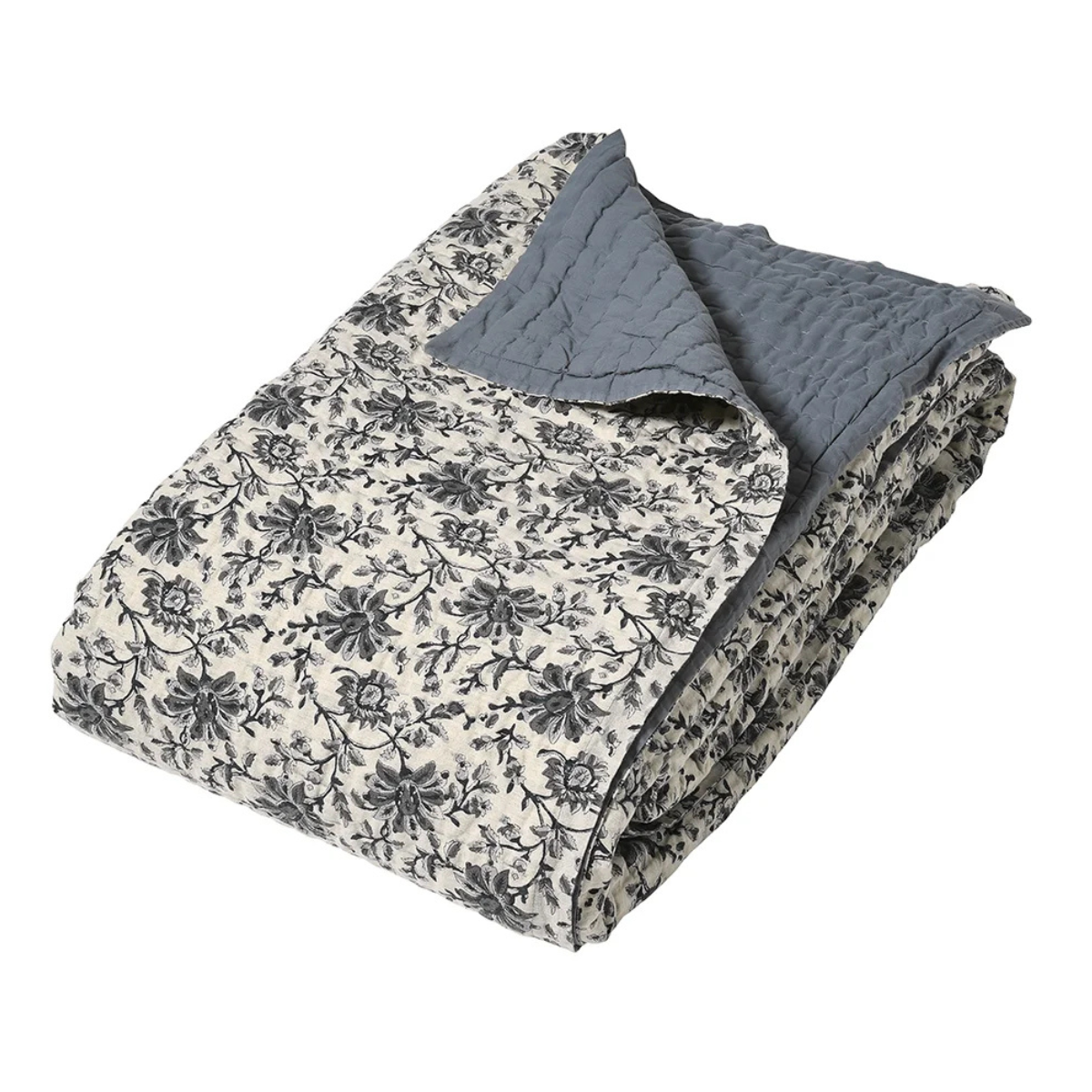 a folded white and grey blue floral bedspread