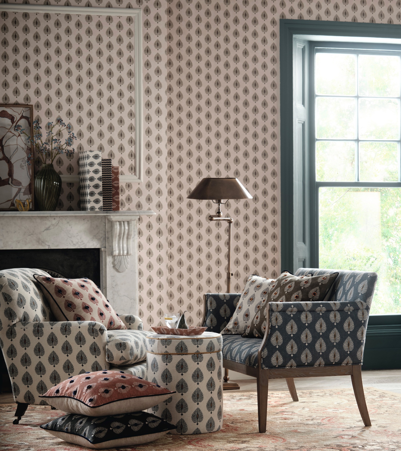 a living room with a cream and red botanical wallpaper with a blue and white patterned armchair
