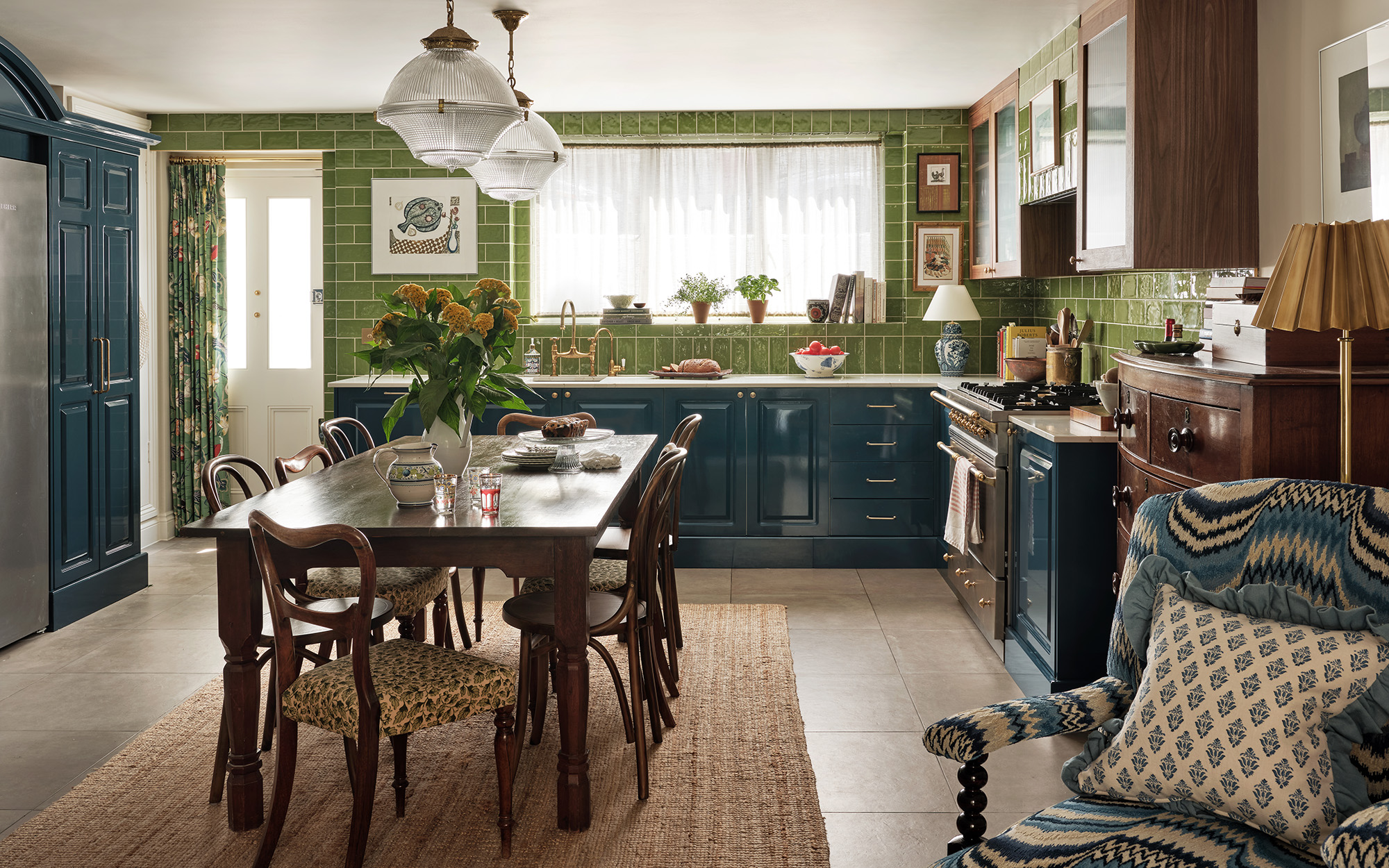 a kitchen with a dining table and green tiles
