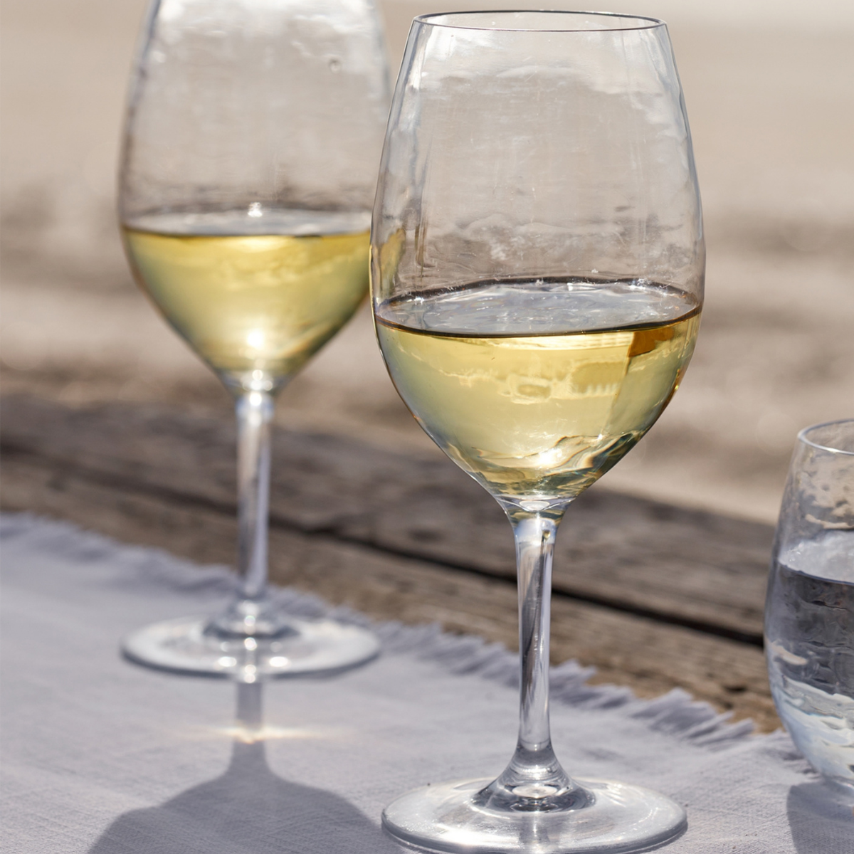 a picnic wine glass full of white wine