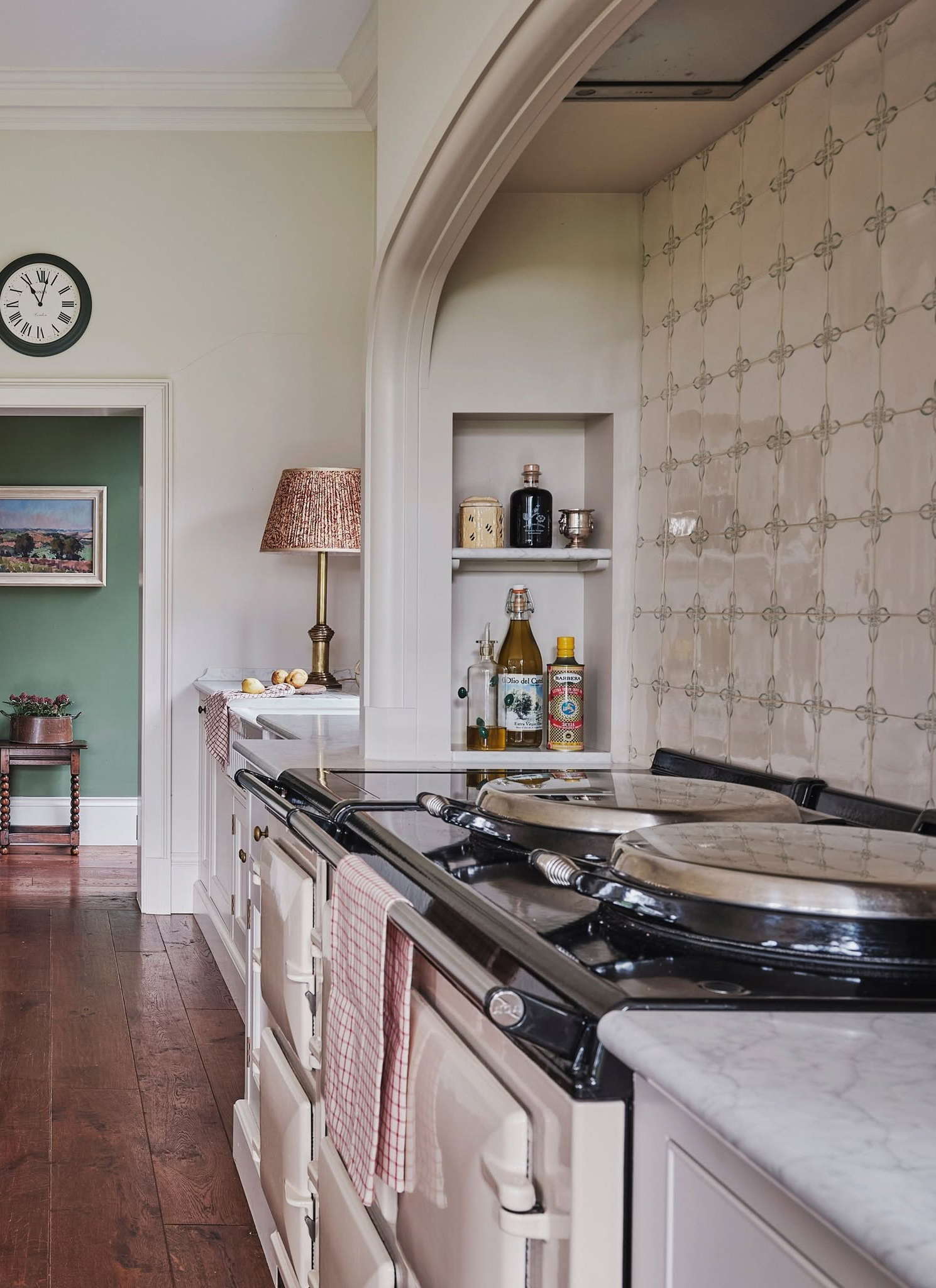 a kitchen with a cream range cooker, white patterned splashback and a recessed shelf built into the cooker surround