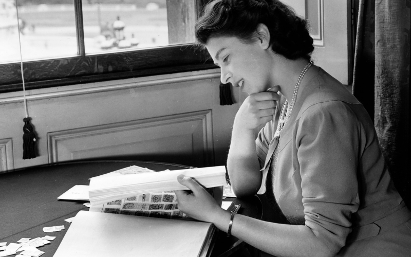 Princess Elizabeth looking through her stamp collection in the State Apartments at Buckingham Palace