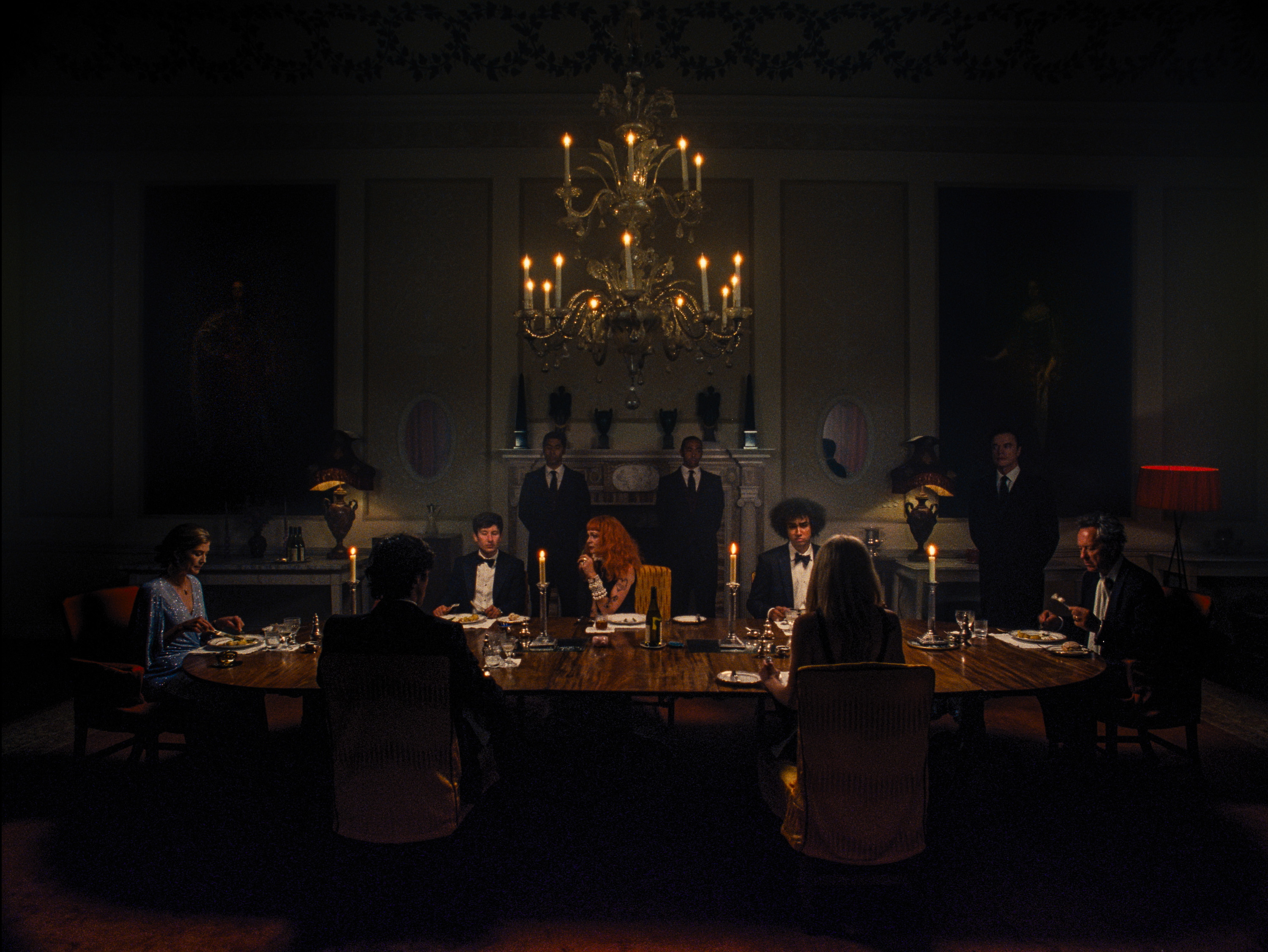 the dining room scene from Saltburn with a large dining table and crystal chandellier