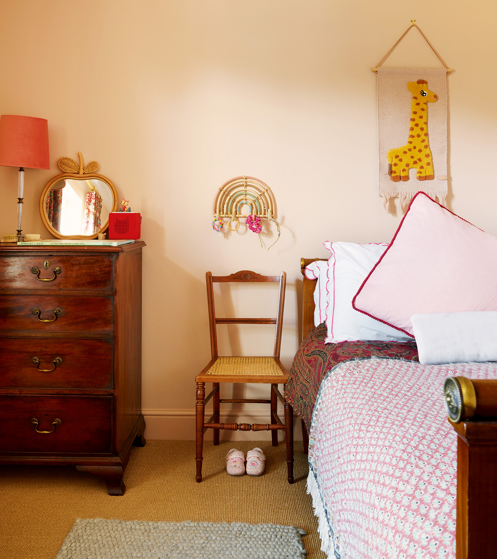 a childrens bedroom with a large antique chest of drawers and a vintage wooden chair
