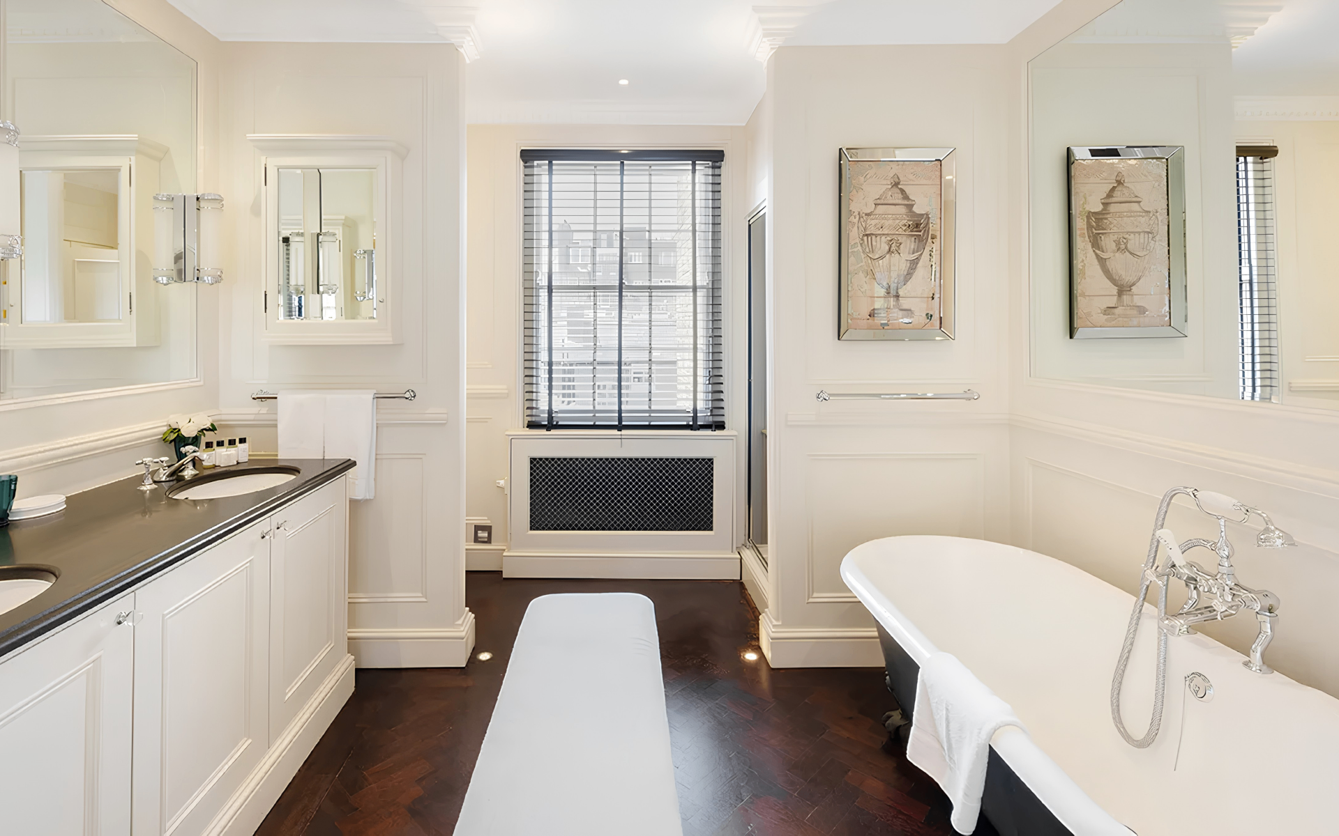 a bathroom in a knightsbridge townhouse with a black and white freestanding bathtub and a large double vanity unit