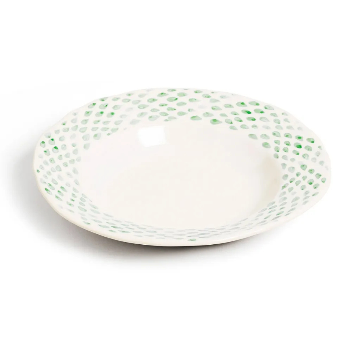 a white pasta bowl with pale green polka dots around the rim