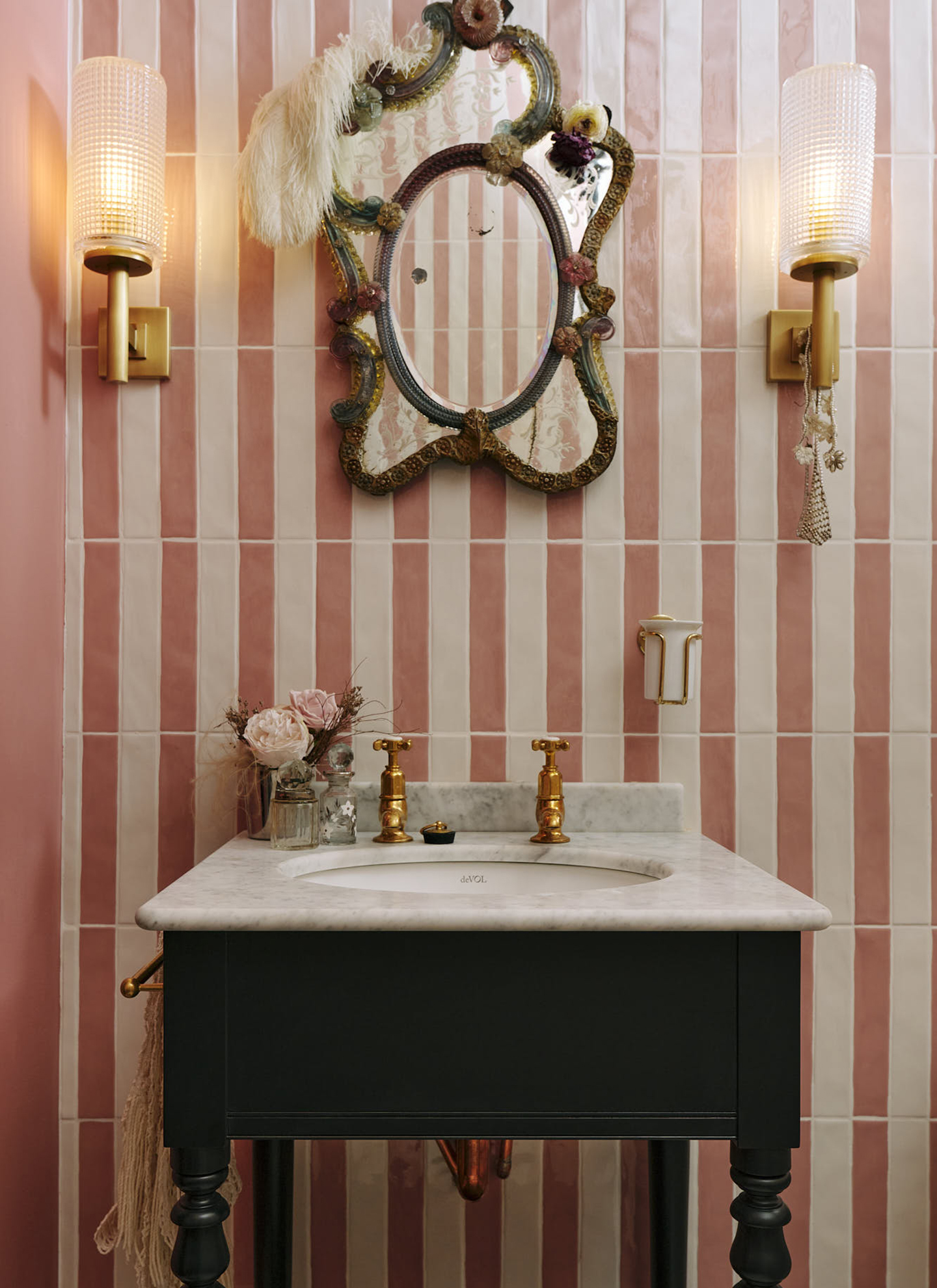 A VICTORIAN WASHSTAND with a marble top against a pink and white striped tile wall