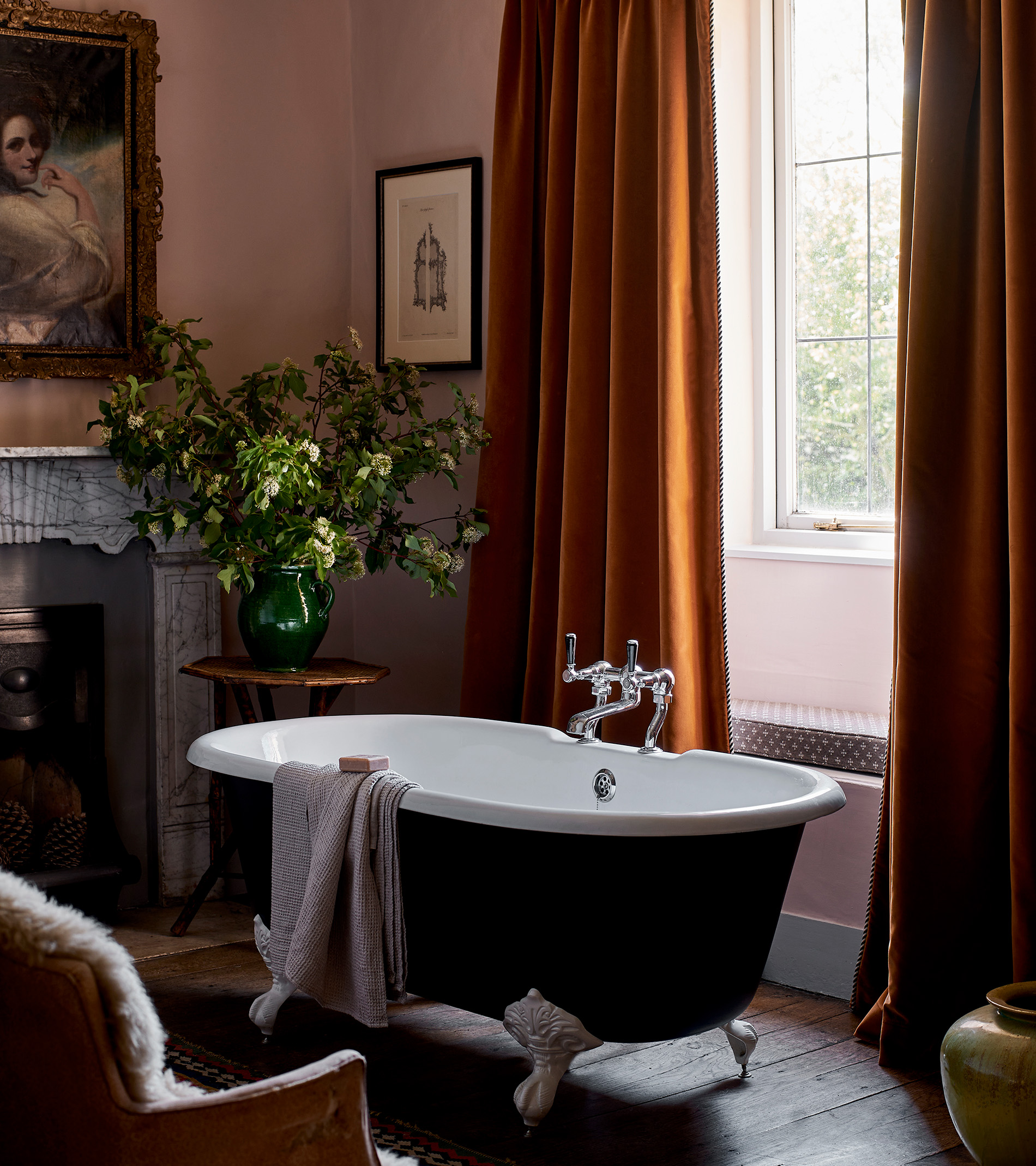 tori murphy fabric curtains in a rust orange colour with a freestanding bath tub in front of it with white clawed feet and a towel draped over the edge