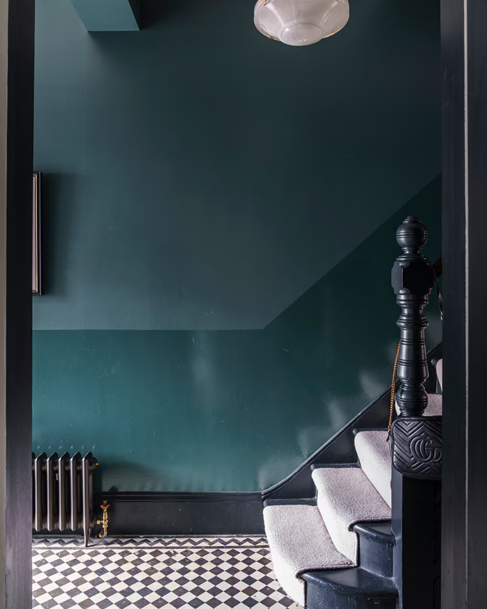 a teal blue hallway with two tone walls and checkered floor