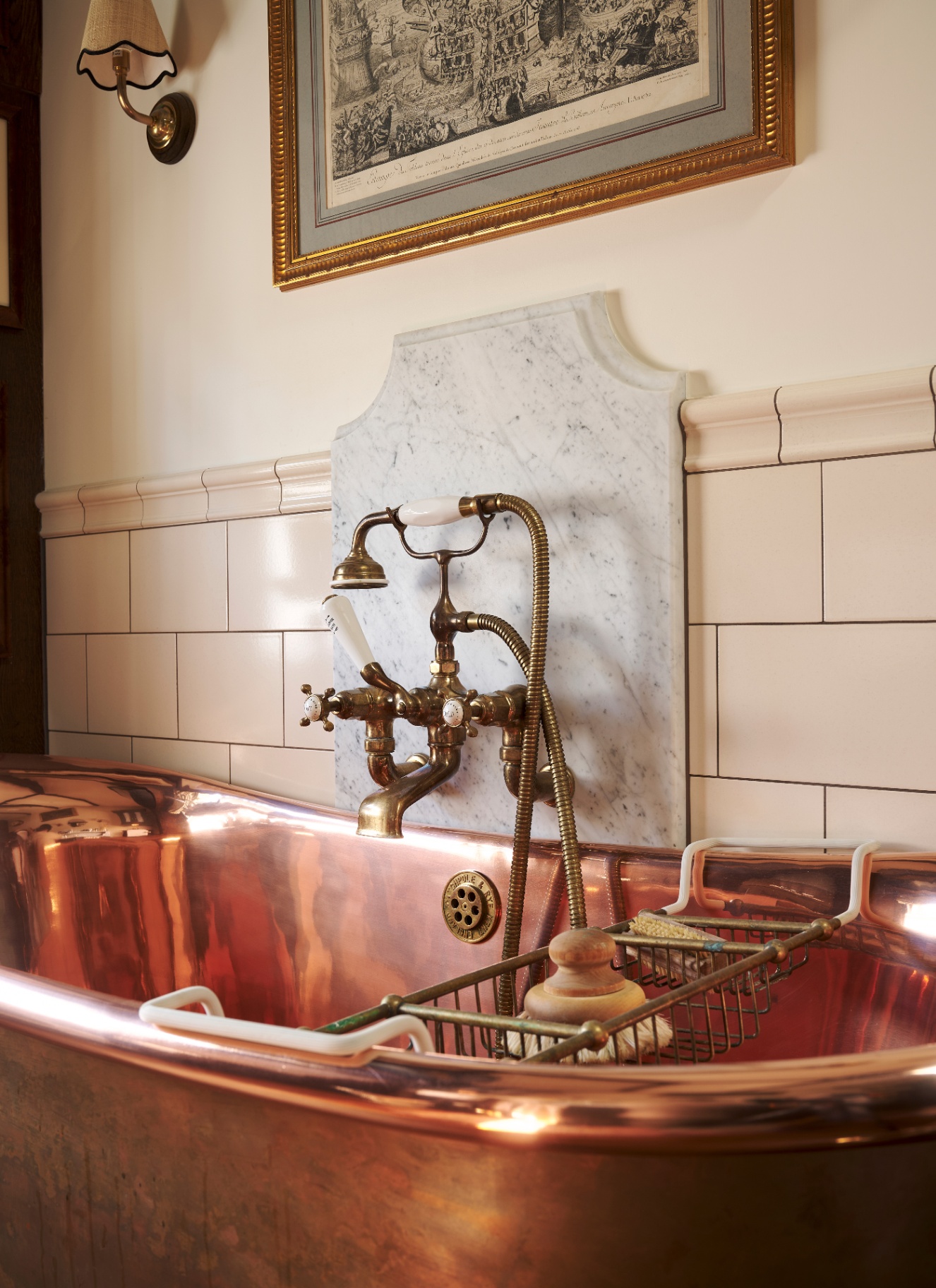 a close up of a copper roll top bath with antique style brass hardware