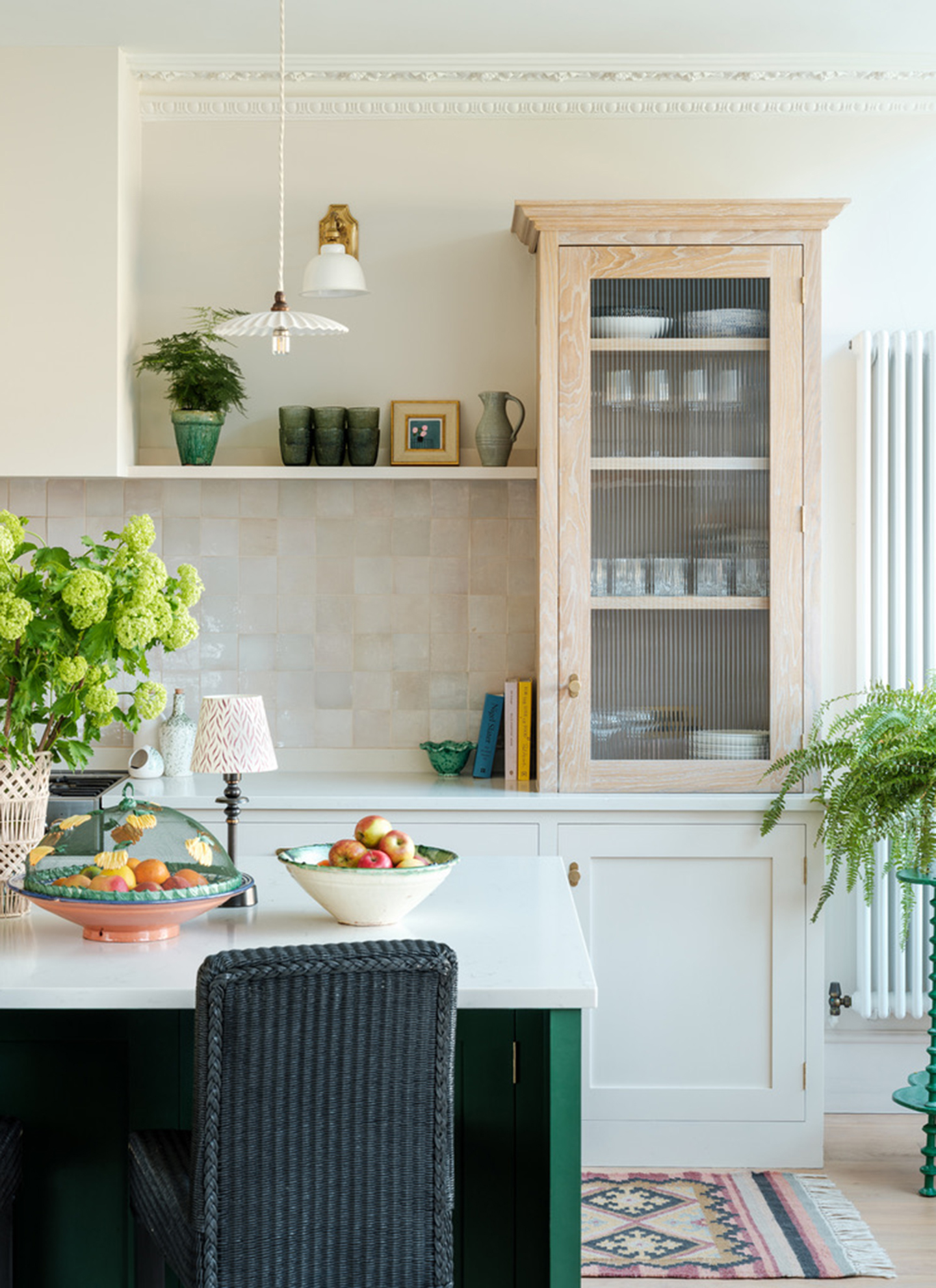 a kitchen with white cabinetry, white walls, a wooden cabinet and white tiles
