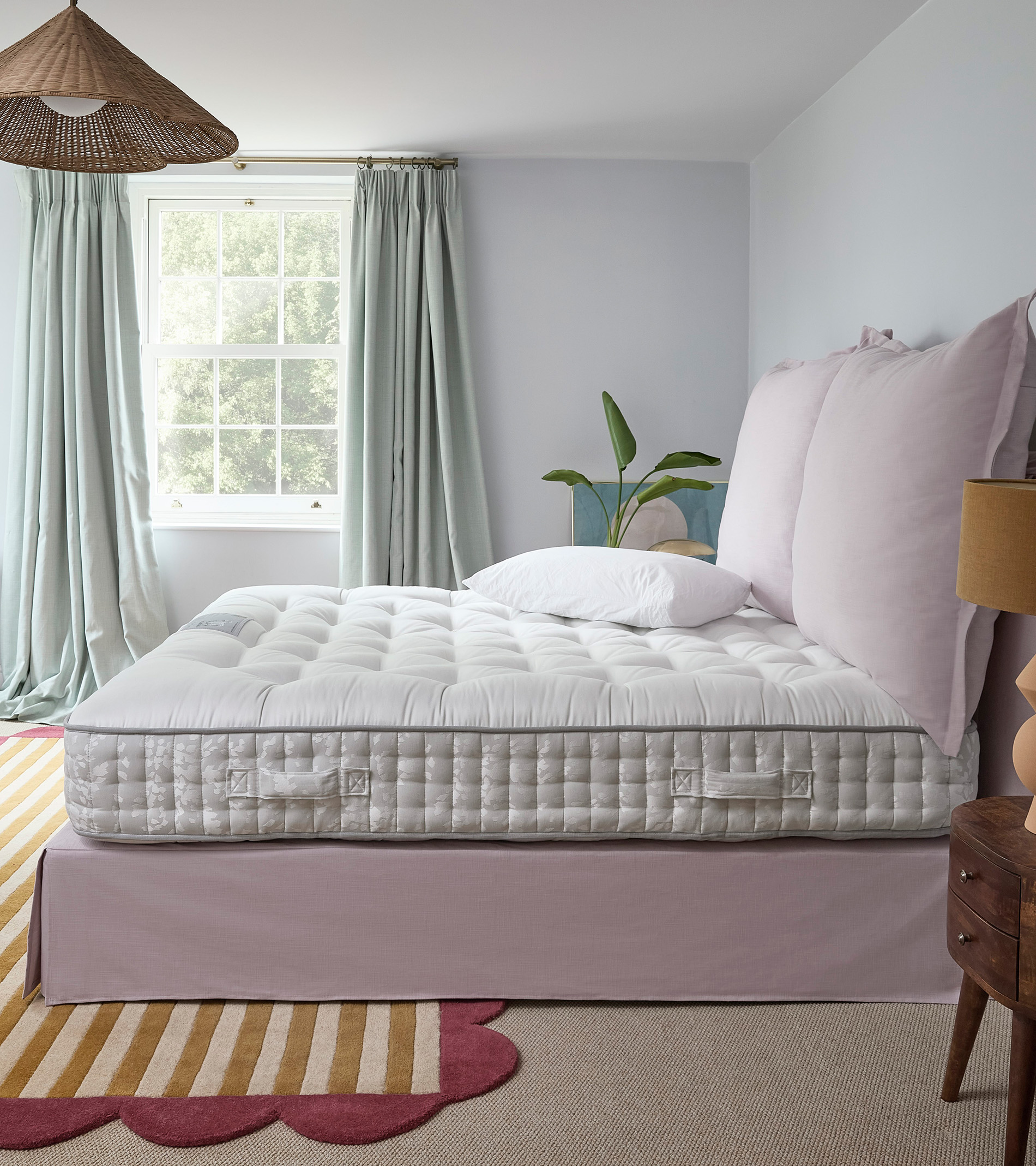bare mattress in a bedroom on a pink bed