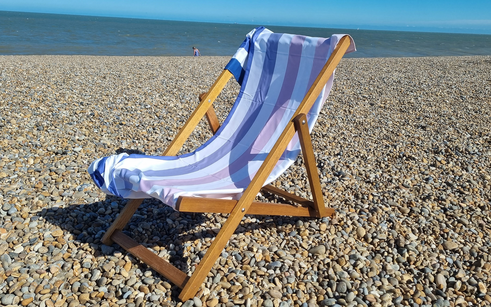 Dusk to Dawn Quick-dry Beach Towel, Dock & Bay pictured on a pebble beach on a deck chair