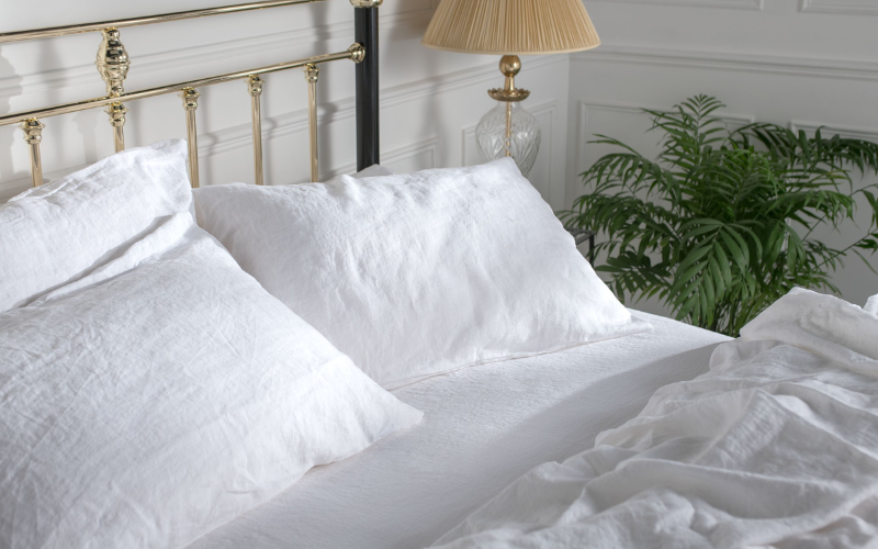 White bedding on a brass bed frame