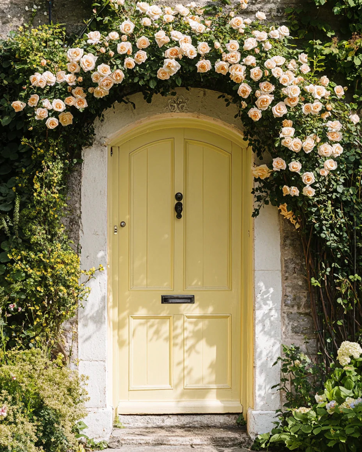 a yellow front door surrounded by roses