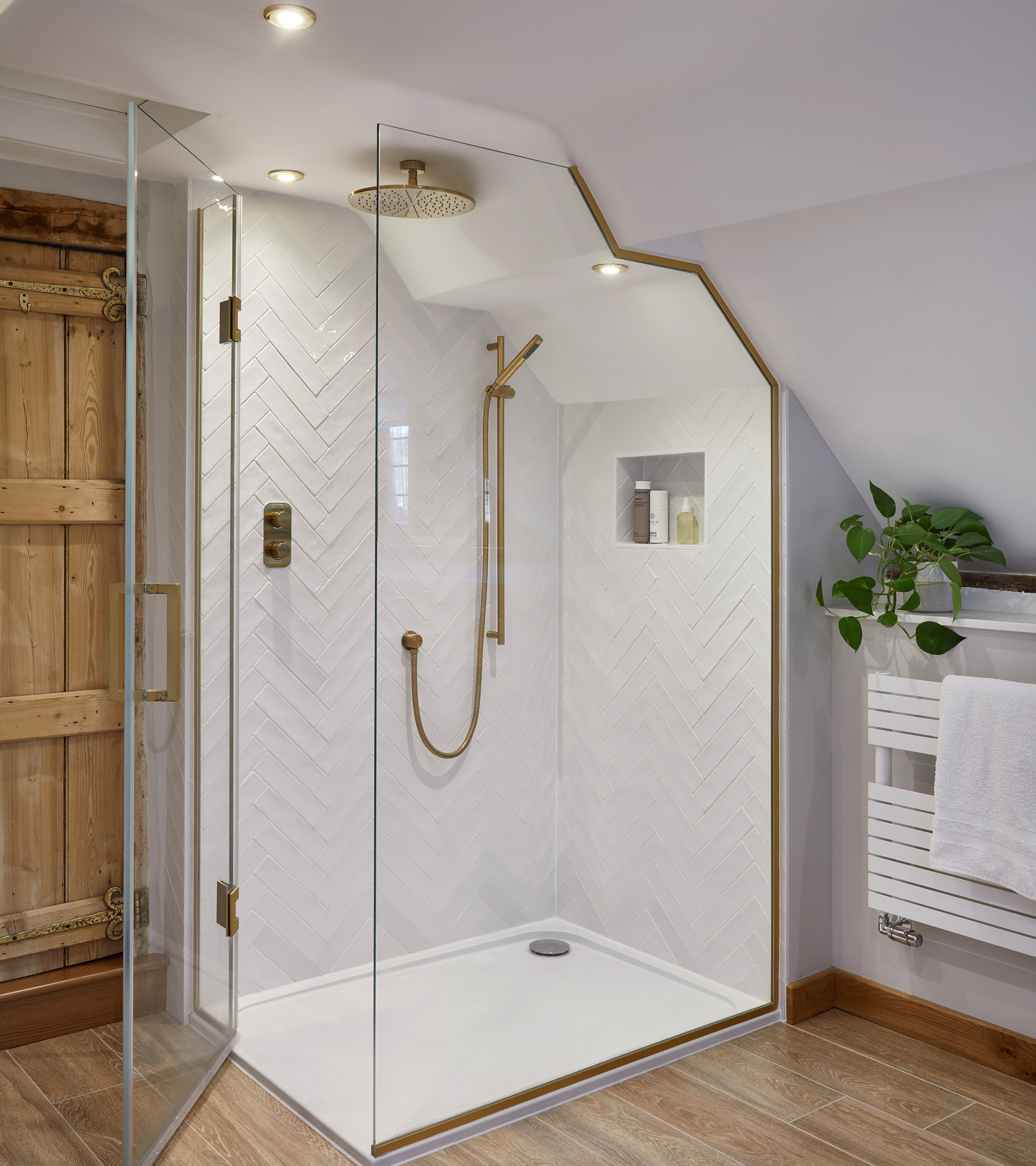 a white tiled shower with glass door