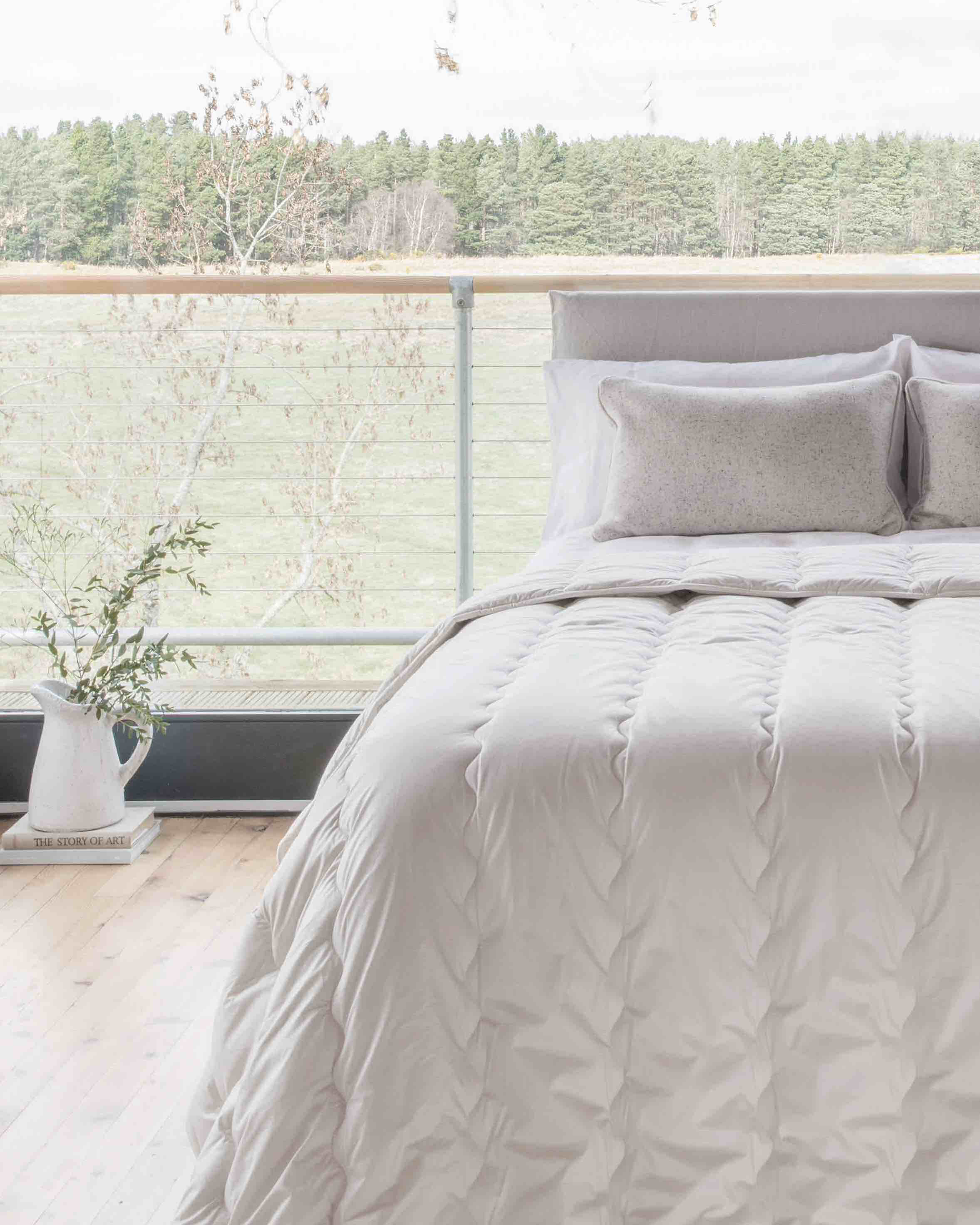 A DUVET ON A bed in front of a large window