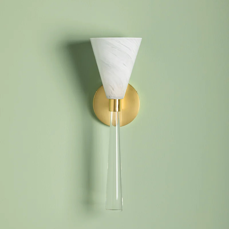a long glass wall sconce with a white glass shade on a soft green background