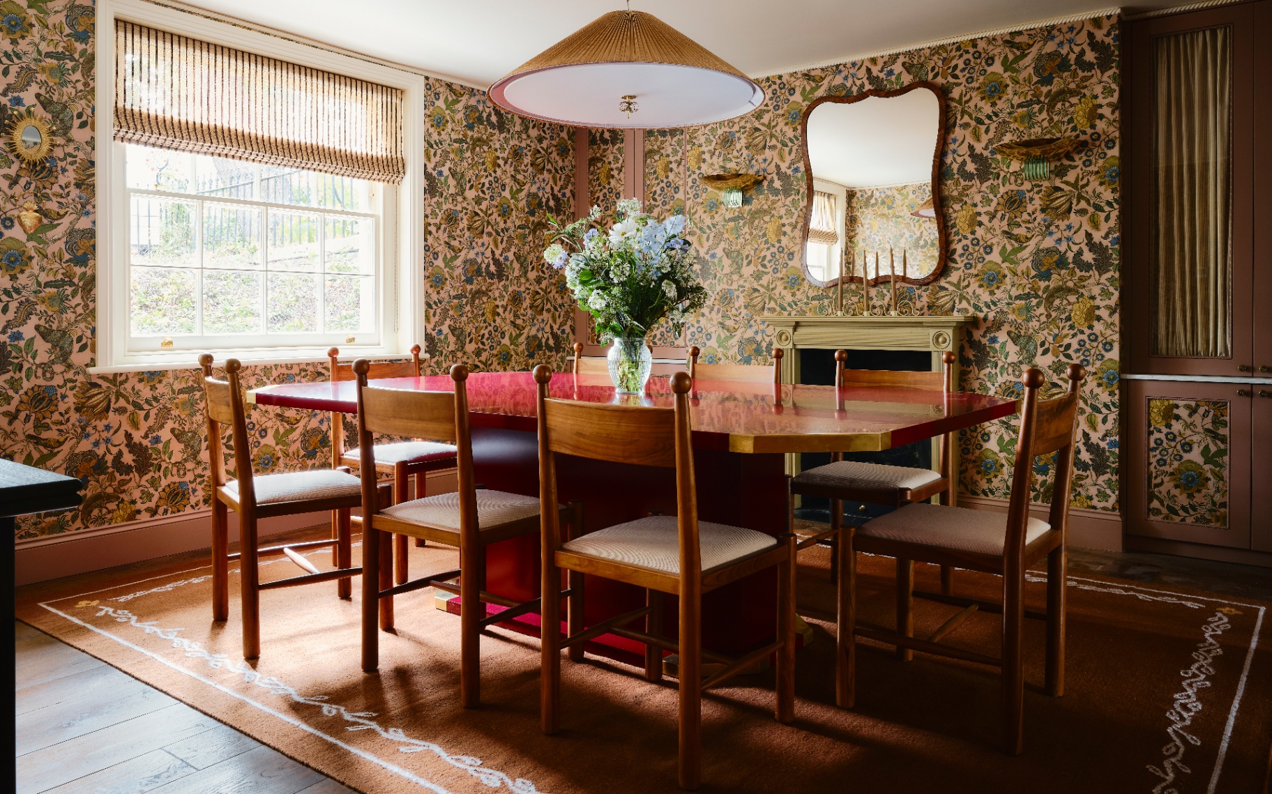 a dining room with earthy floral wallpaper and a shiny dining table1