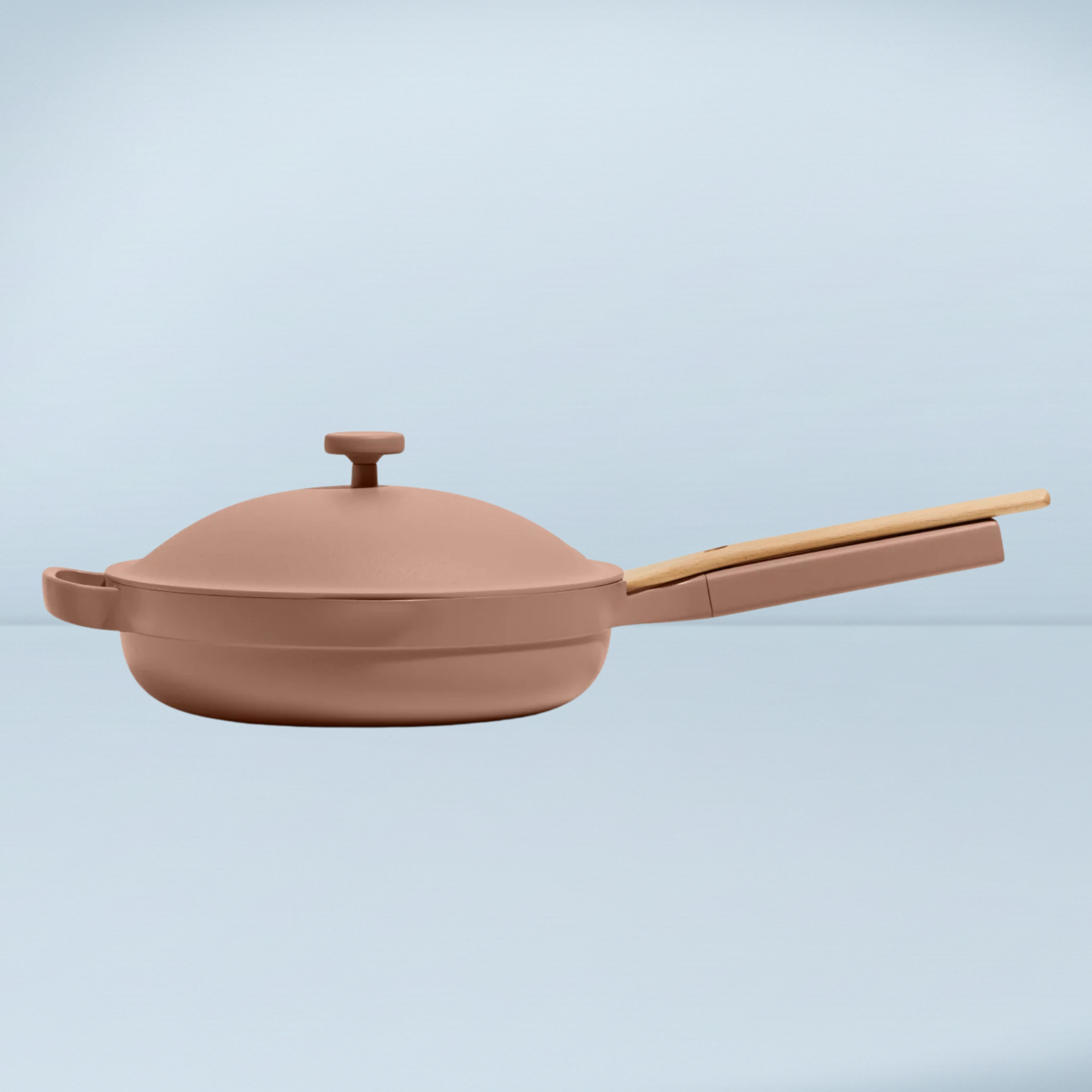 pink frying pan with a lid and a wooden spoon