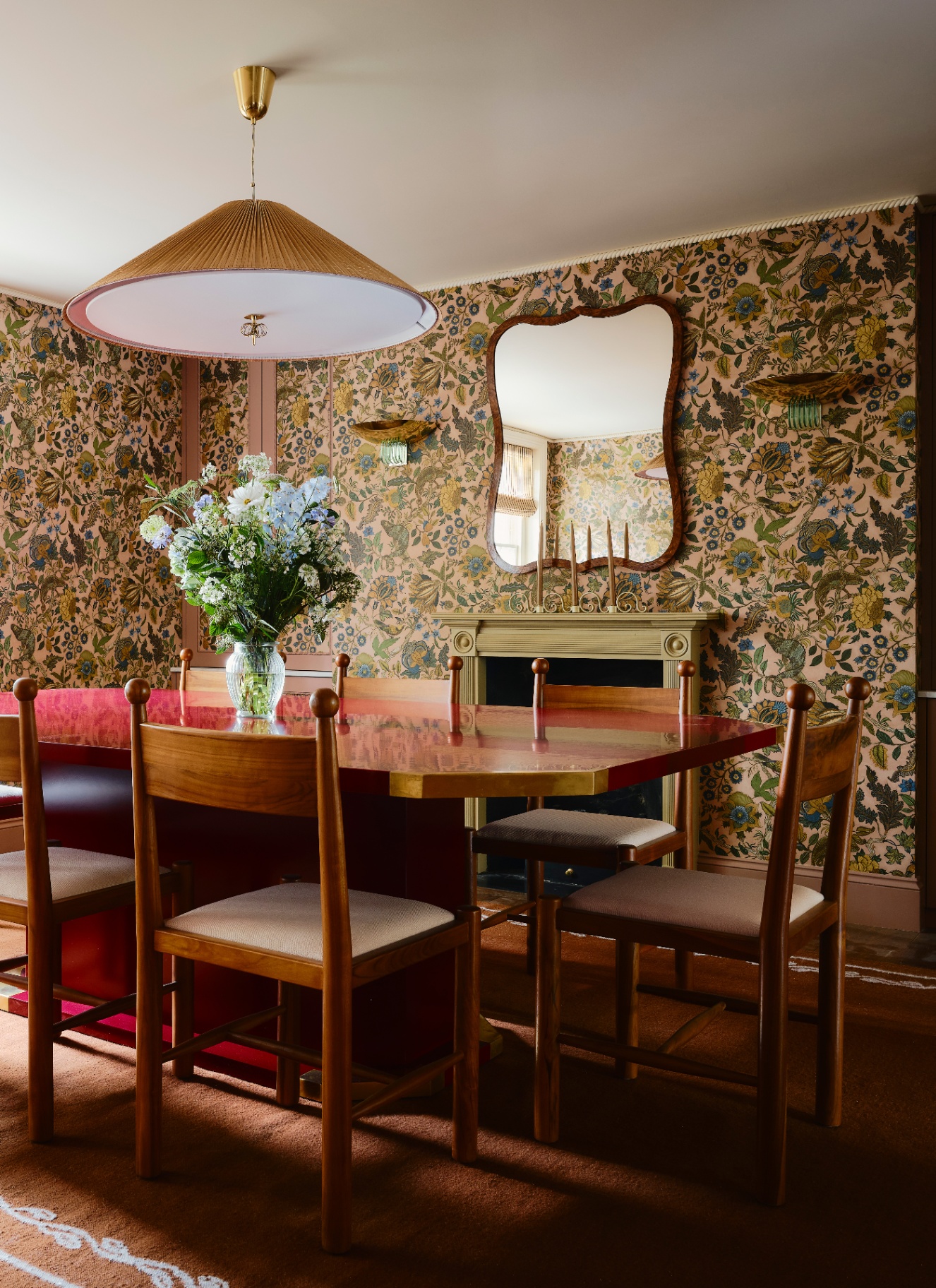 a dining room with earthy floral wallpaper and a shiny dining table