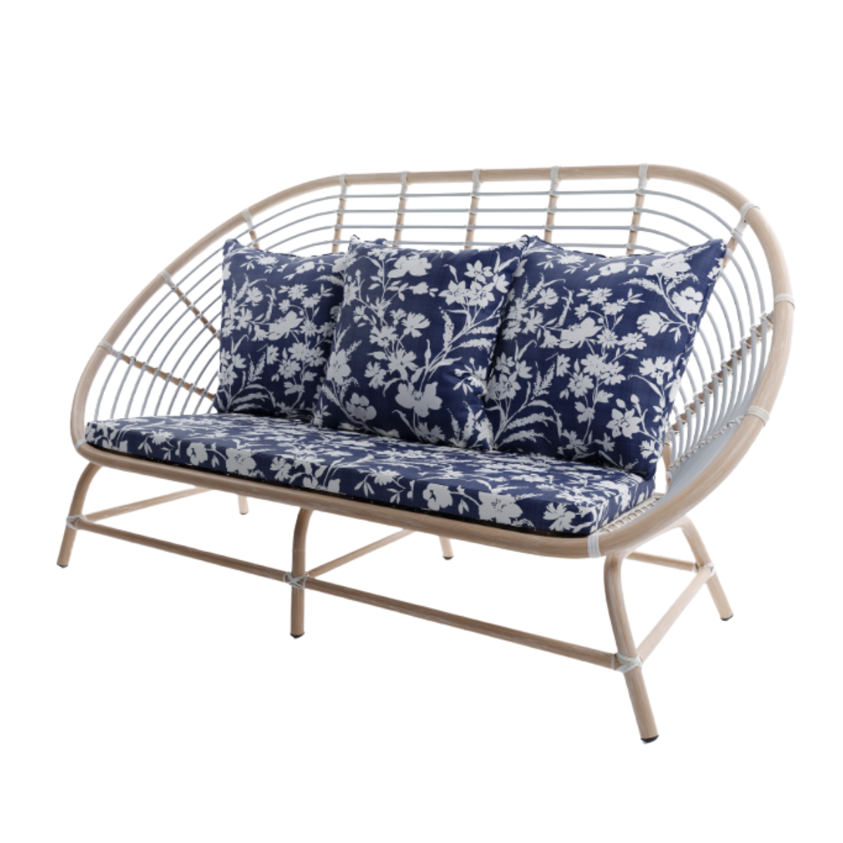 a cane garden sofa with navy and white floral cushions